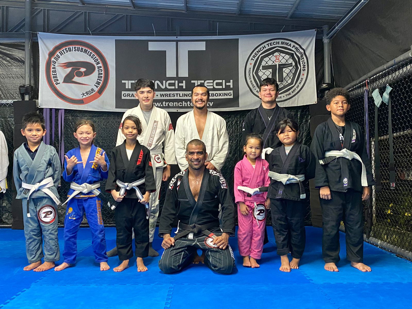 Front row, from left, Brian Anthony Reyes, Reiden Palacios Travilla, Kaiya Isabel Pangelinan, head coach Cuki Alvarez, Leihani'Lyn Faith Reyes, Jacqueline Iris Quitugua, Justo Jeremiah Quitugua; back row, Gabriel Mitchell, assistant coach Alverick Alvarez and Chris Hardt pose. The Trench Tech Purebred Saipan Kids will compete in the Påtgon Brazilian Jiu Jitsu Tournament this Saturday at the UOG Fieldhouse on Guam.