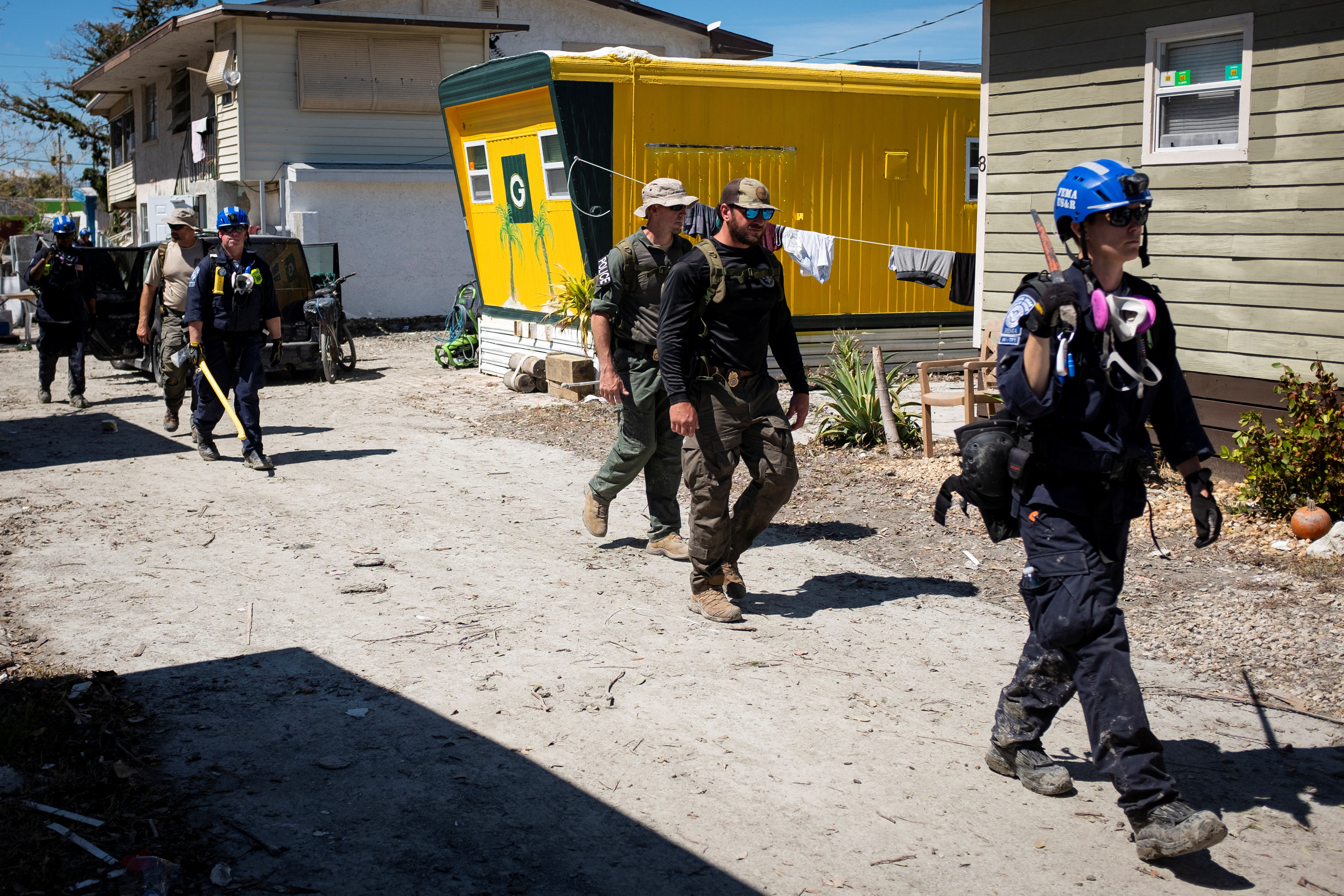 FEMA agents and Lee County Sheriff officers walk by a trailer park after Hurricane Ian caused widespread destruction in Fort Myers Beach, Florida, October 3, 2022.