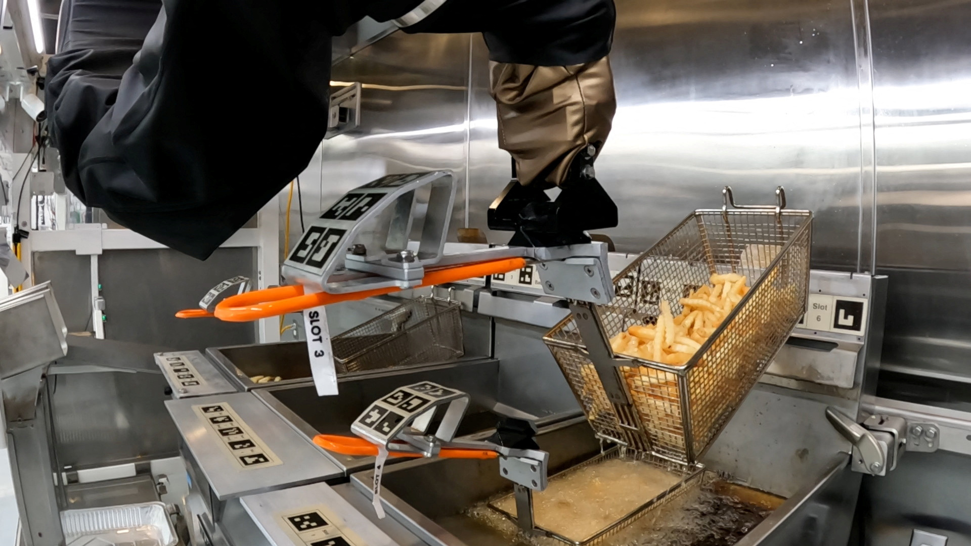 The Flippy 2 robot takes fries out of a vat of oil at a lab of manufacturer Miso Robotics Inc in Pasadena, California, Sept. 27, 2022, in this screen grab from a REUTERS video.