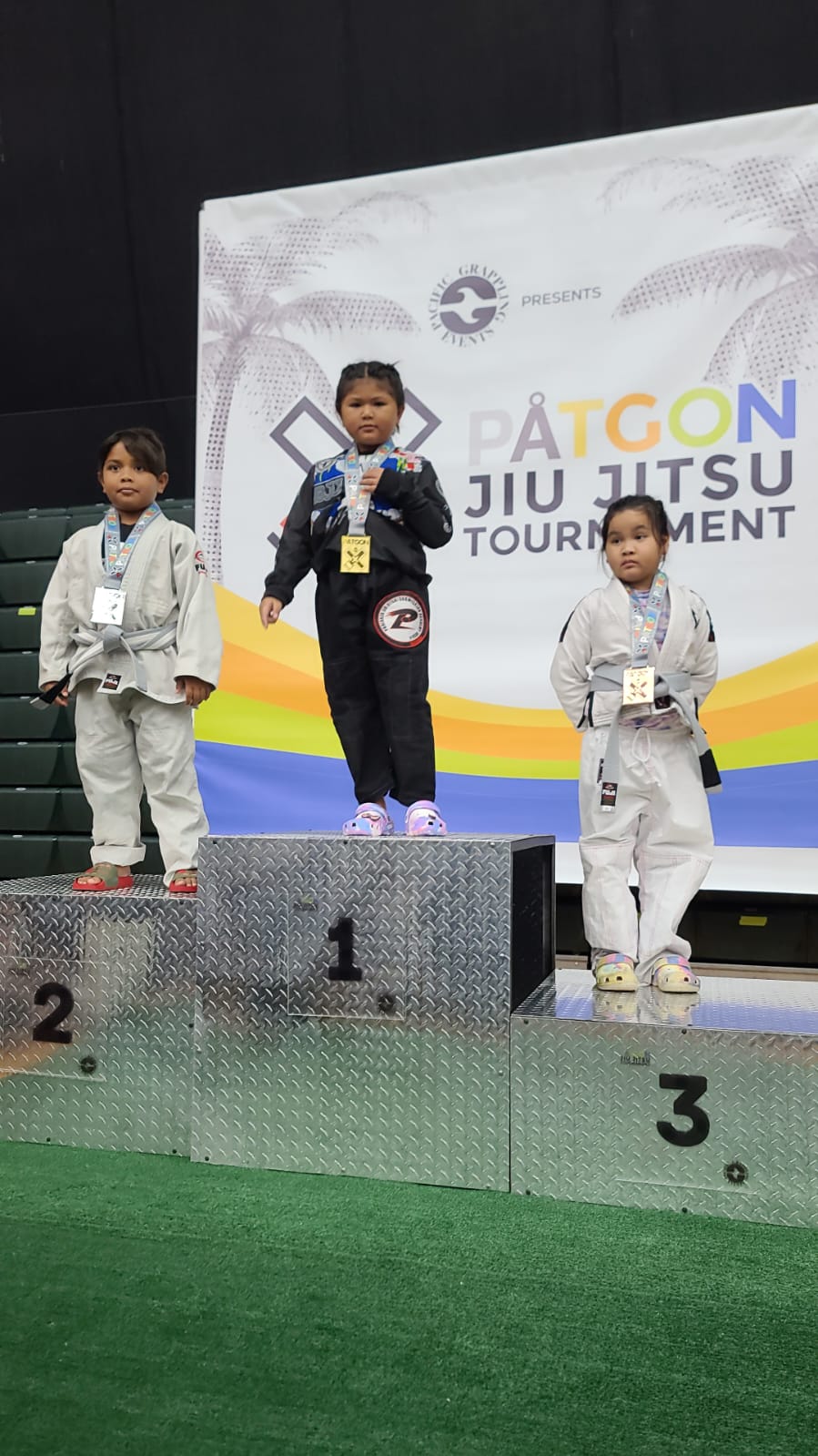 Jacqueline Quitugua, center, wins the gold medal in the Peewee Super Heavyweight Division of the Påtgon Brazilian Jiu Jitsu Tournament at the UOG Fieldhouse on Guam Saturday.