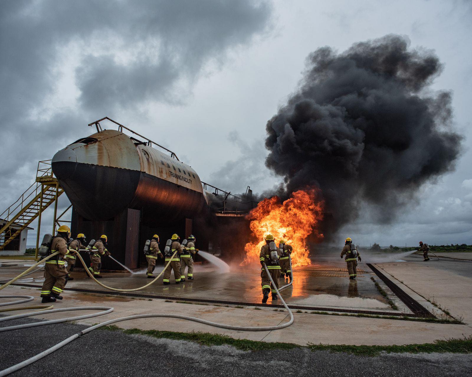 Airport firefighters work together to put out a fire during a drill on Saipan.
