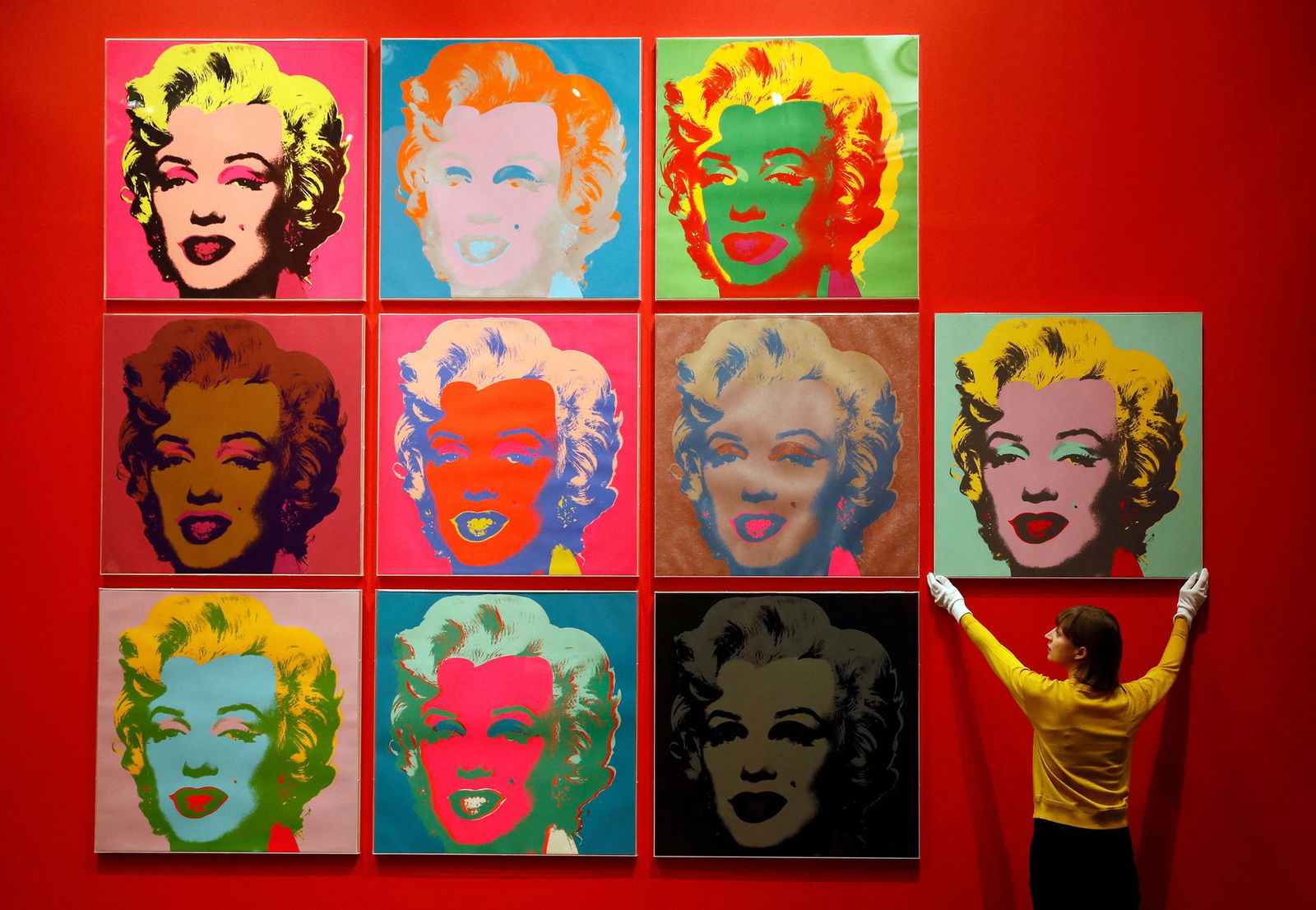 An employee poses with 10 screenprints of Marilyn Monroe by Andy Warhol as part of the exhibition "American Dream: pop to the present" at the British Museum in London, Britain, Feb. 10, 2017.