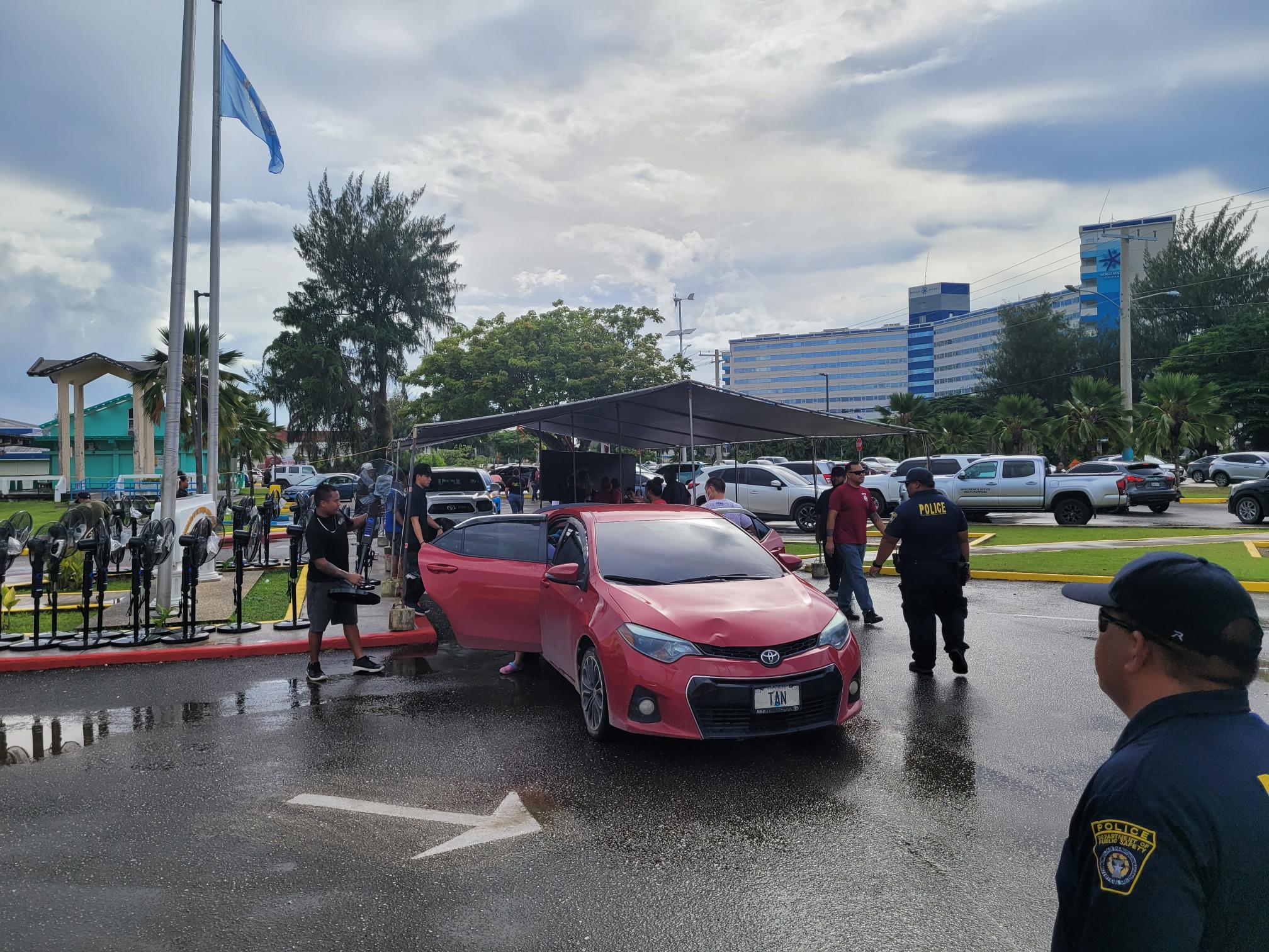 A government staffer loads an electric fan into a vehicle.