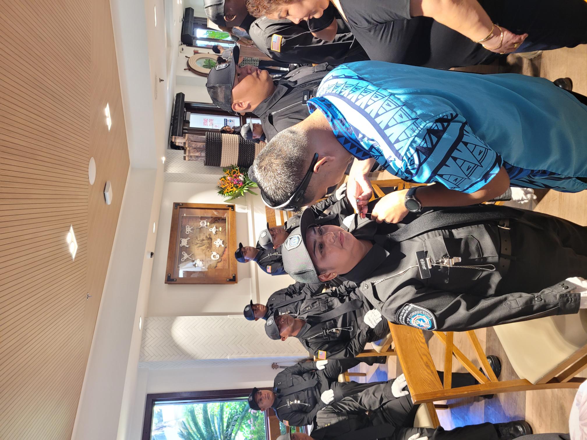 Beti Javier pins the Corrections badge on his wife Maria Sarah C. Javier during the 9th Cycle Corrections Academy graduation ceremony.