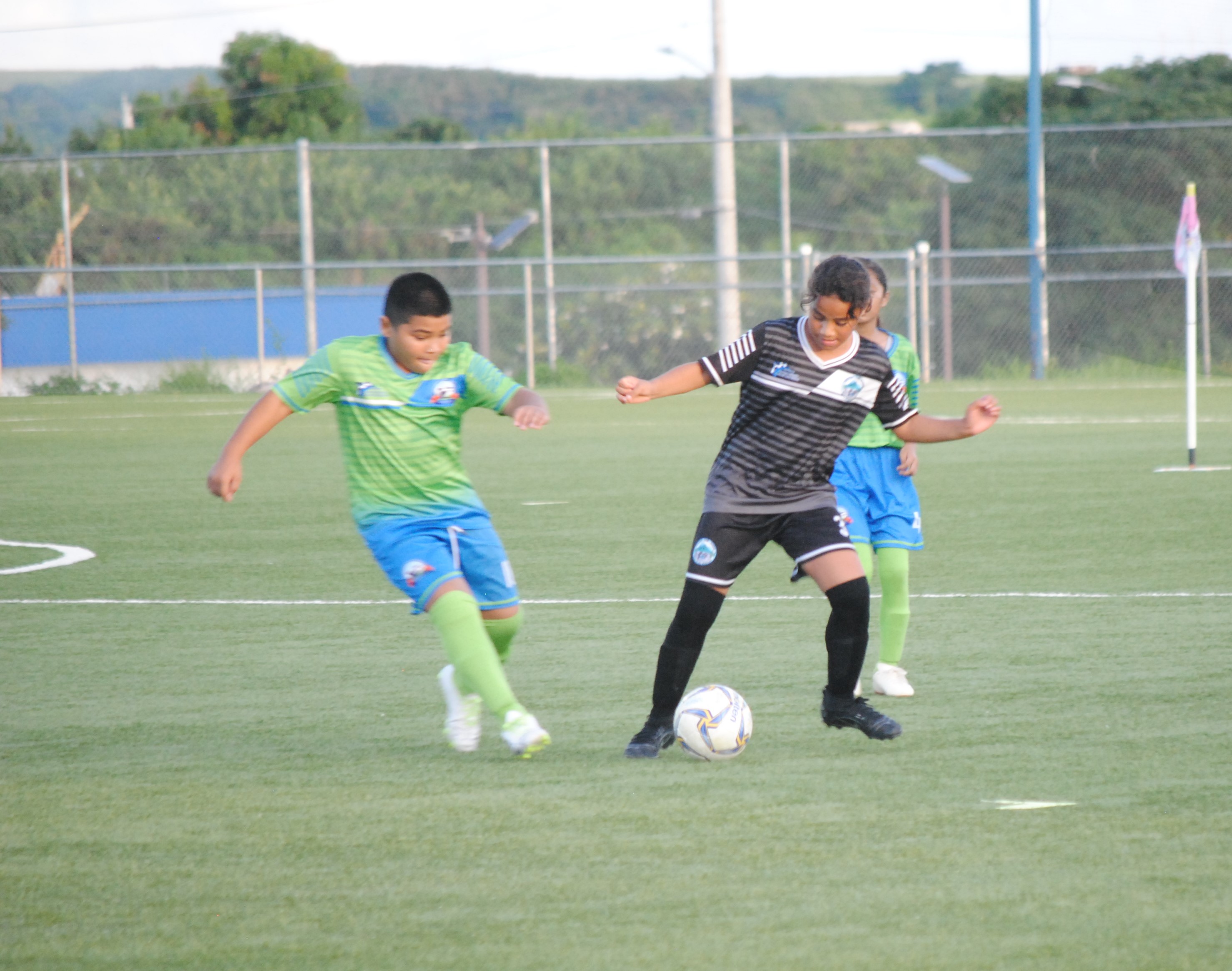 GES 1's Adrianna Marciano protects the ball as WSR 2's Izaiah Tenorio closes in.
