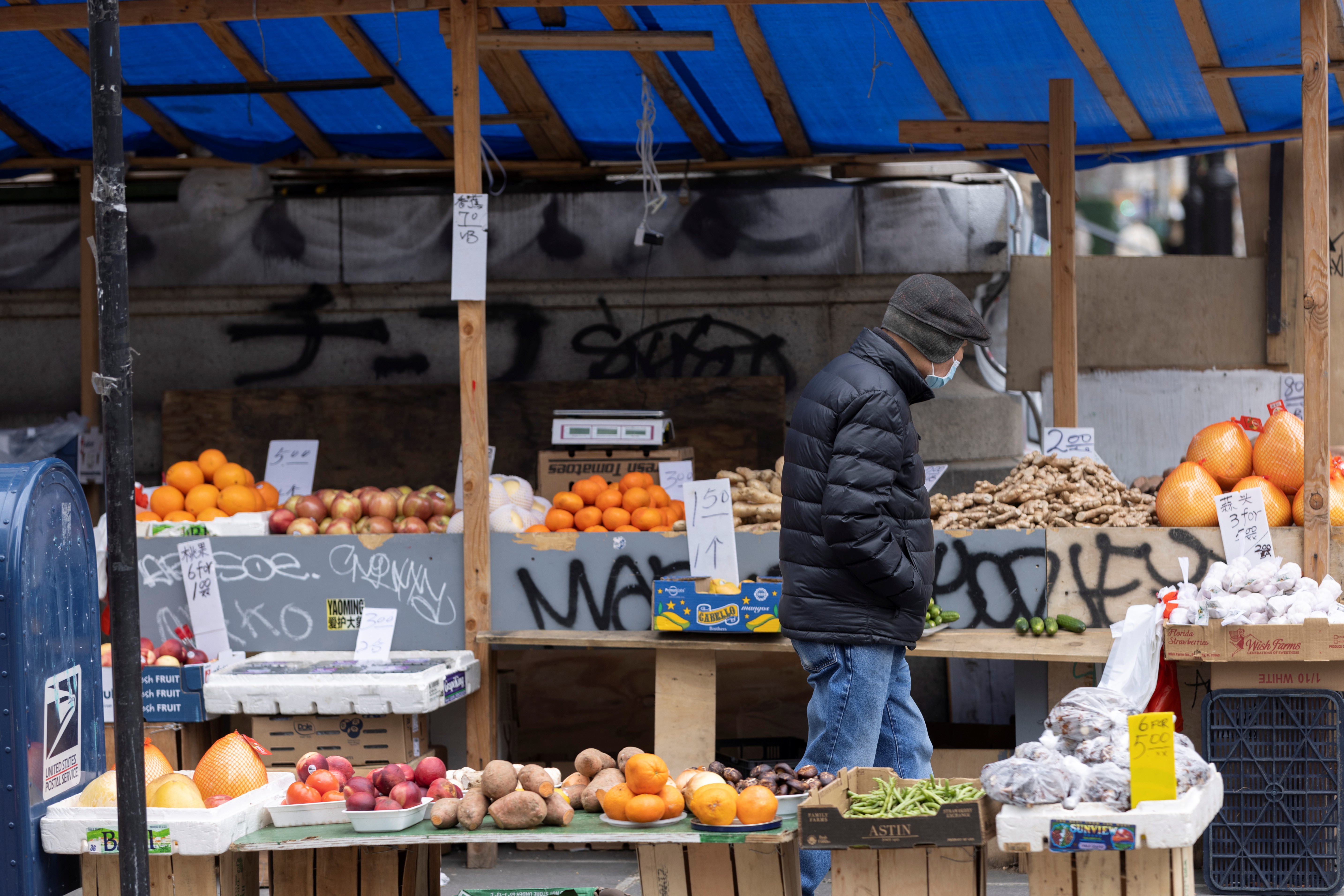 A person walks past a stall selling fruit and vegetables in Manhattan, New York City, March 28, 2022.