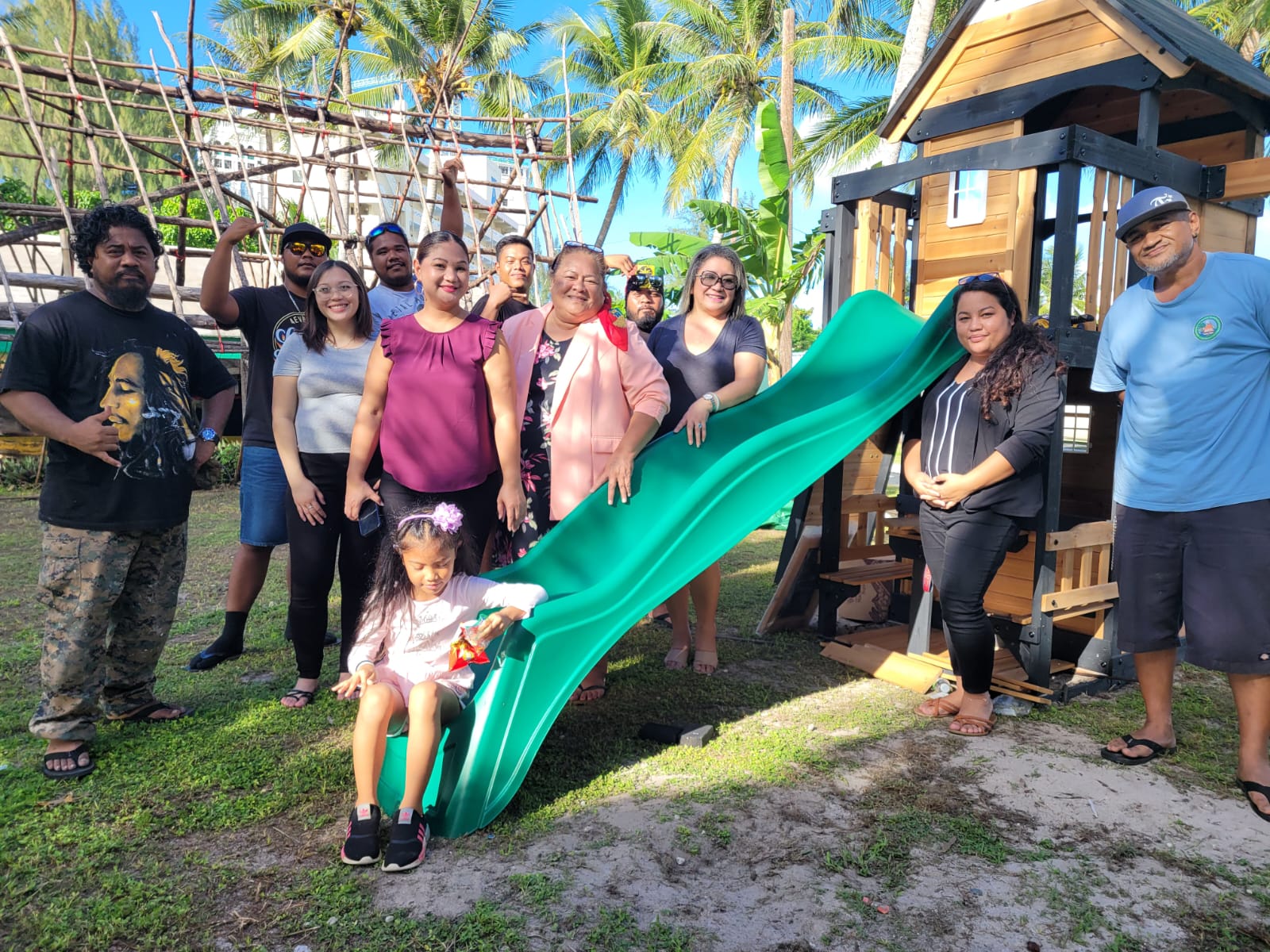 Sen. Edith Deleon Guerrero, third right, Rep. Corina Magofna, center, and  Rep. Denita Yangetmai, fourth right, pose for a photo with their office staff members and community workers after installing brand new play equipment at the Carolinian Affairs Office in Garapan on Wednesday.