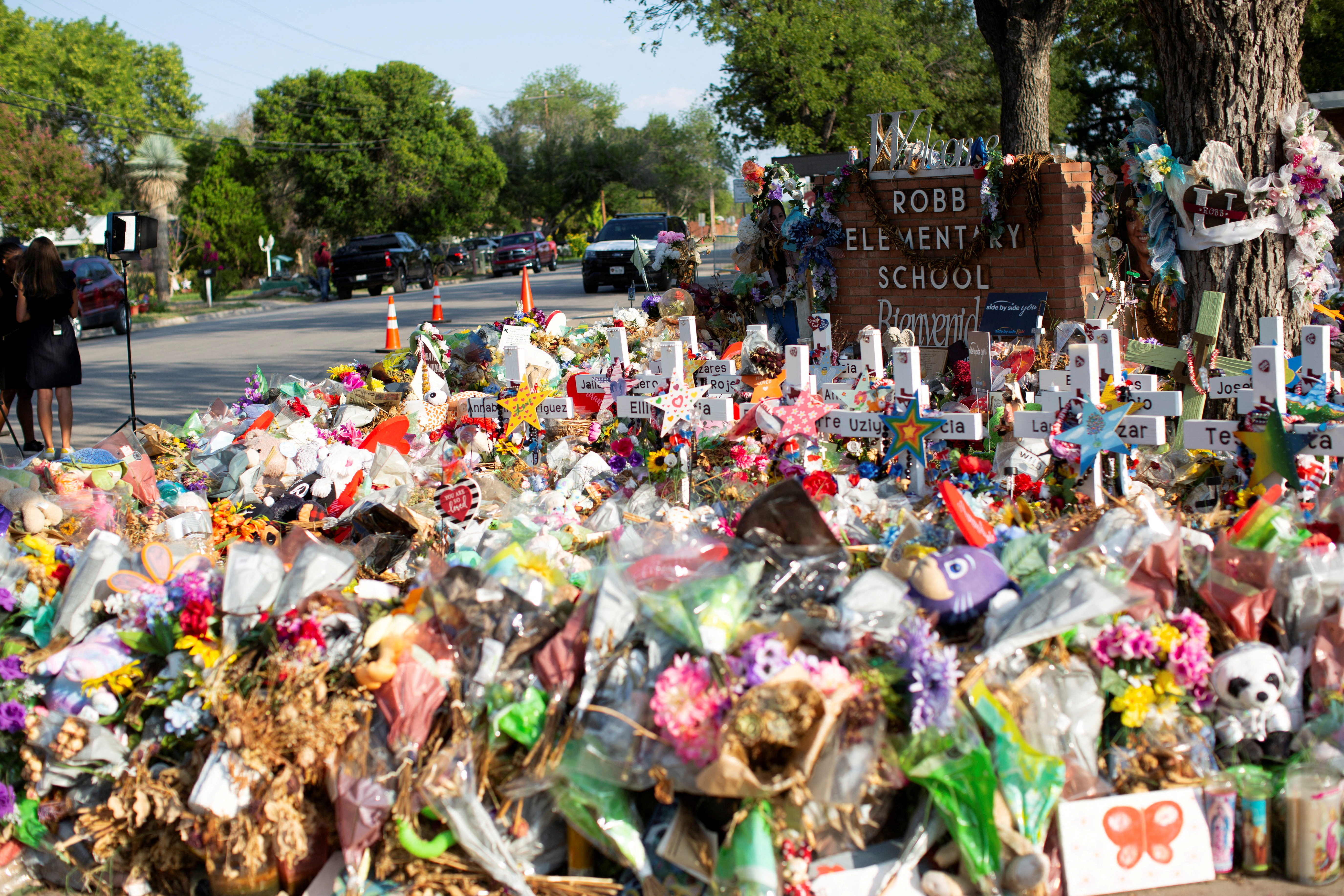 Weathered signs, candles and stuffed animals remain at a memorial outside Robb Elementary School the day after the video showing the May shooting inside the school released, in Uvalde, Texas, July 13, 2022.
