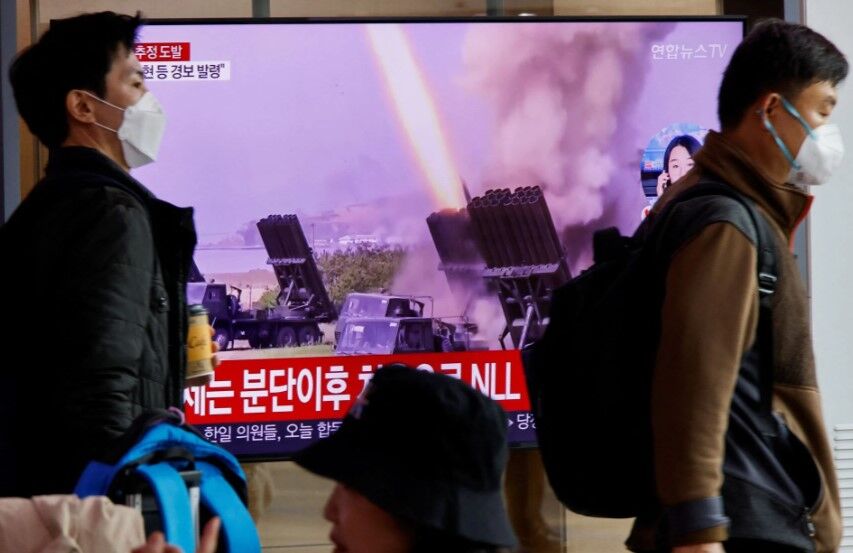 Men walk past a TV broadcasting a news report on North Korea firing a ballistic missile off its east coast, in Seoul, South Korea, Nov. 3, 2022.