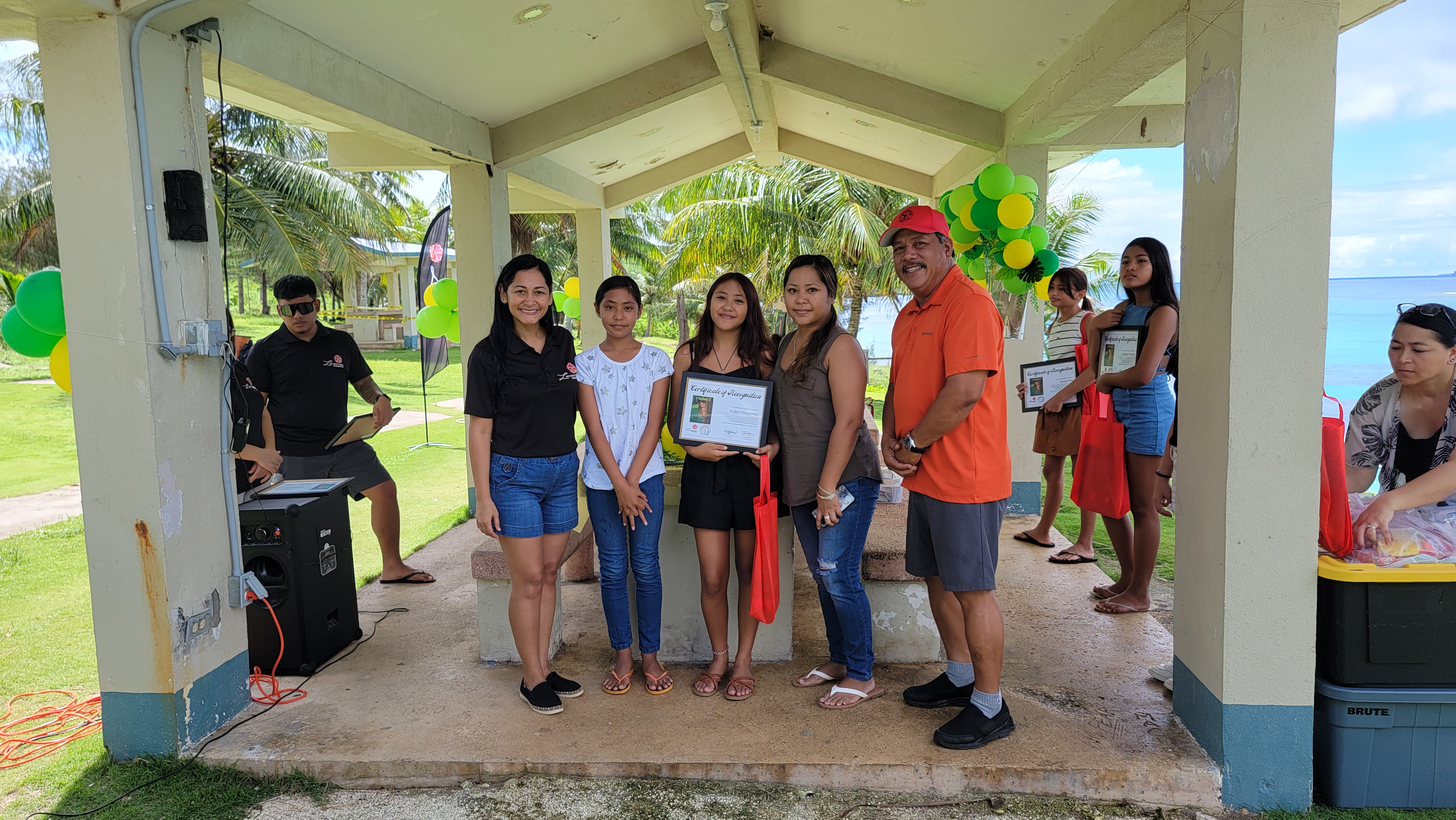 I Duendis 2 author Kiyani Villagomez receives her certificate of recognition from first lady Diann Torres. Also in photo are Tinian Mayor Edwin Aldan and family members.