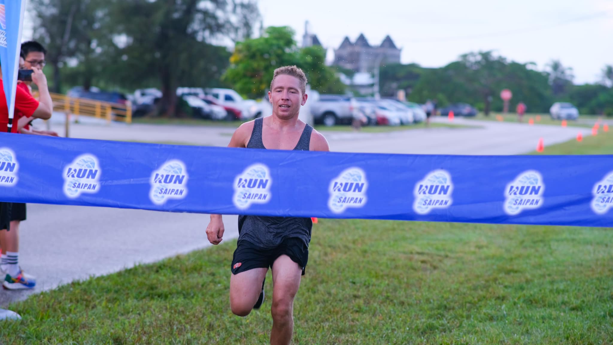 Paul Timm smiles as he finishes first in the 8K open division of the Saipan International Airport Trail Run Saturday on Continental Road near United Air Cargo.