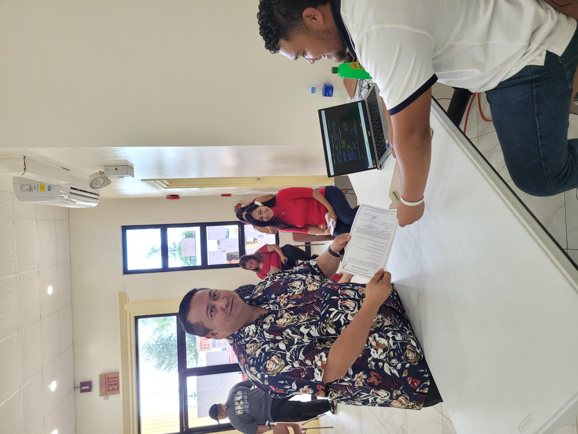 Gov. Ralph DLG Torres hands his early-voter form to an election commission staff member at the multi-purpose center Thursday. Also in photo: first lady Diann T. Torres.
