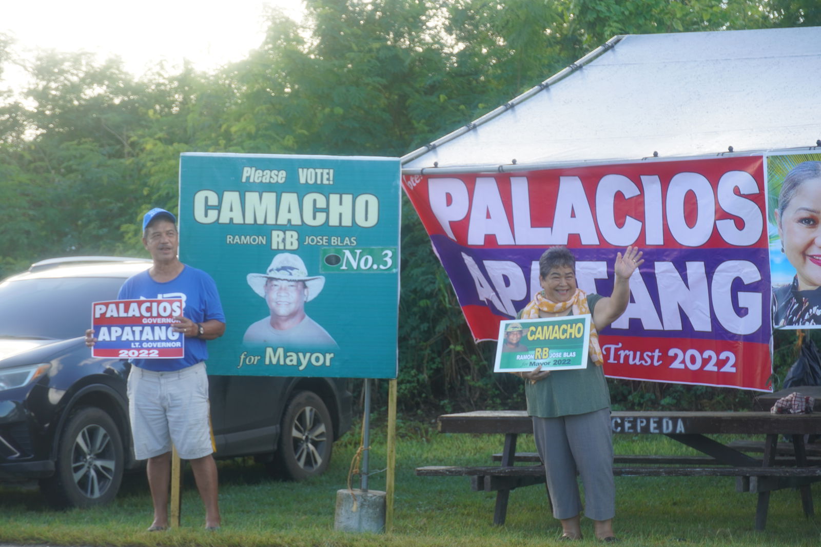Delia M. Camacho, right, wife of Independent mayoral candidate Ramon B. Camacho waves to motorists in Precinct 3 along with another Independent supporter.