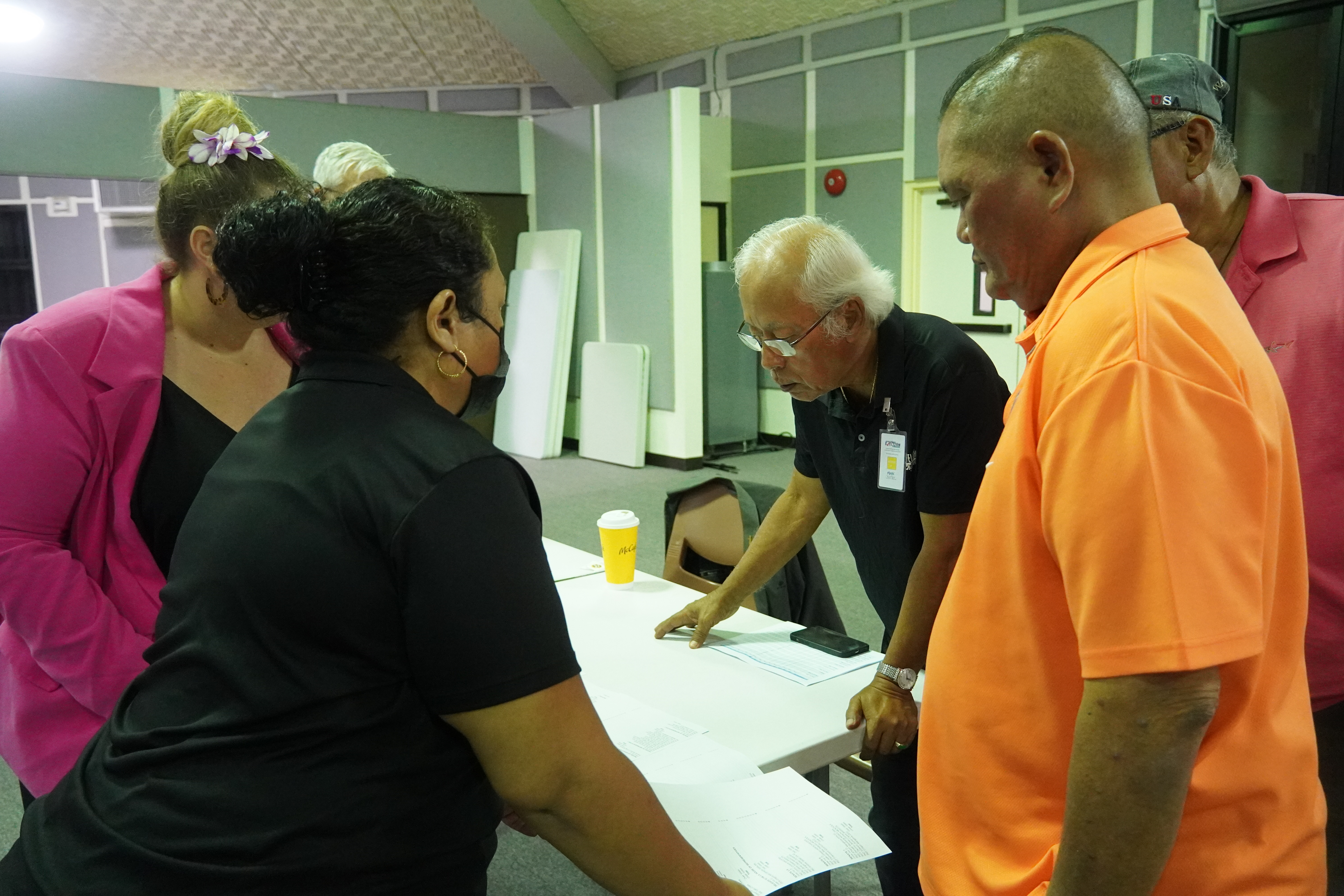 Commonwealth Election Commission Executive Director Kayla S. Igitol and Office of the Public Auditor legal counsel Ashley Kost show a printout to election observers, marking the beginning of the general election tabulation.