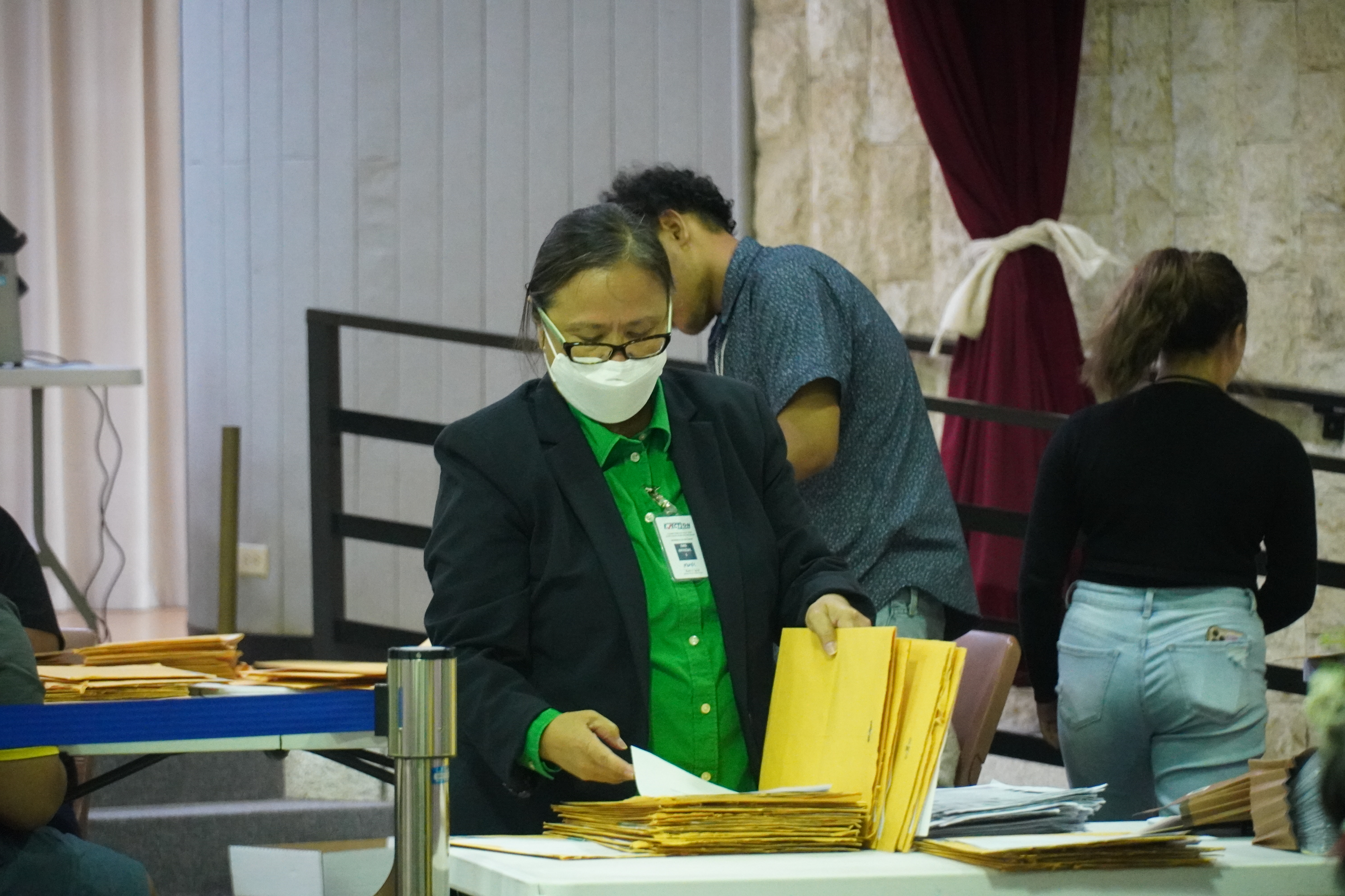 Deputy Attorney General Lillian Tenorio sorts through absentee ballots on election night at the multi-purpose center.