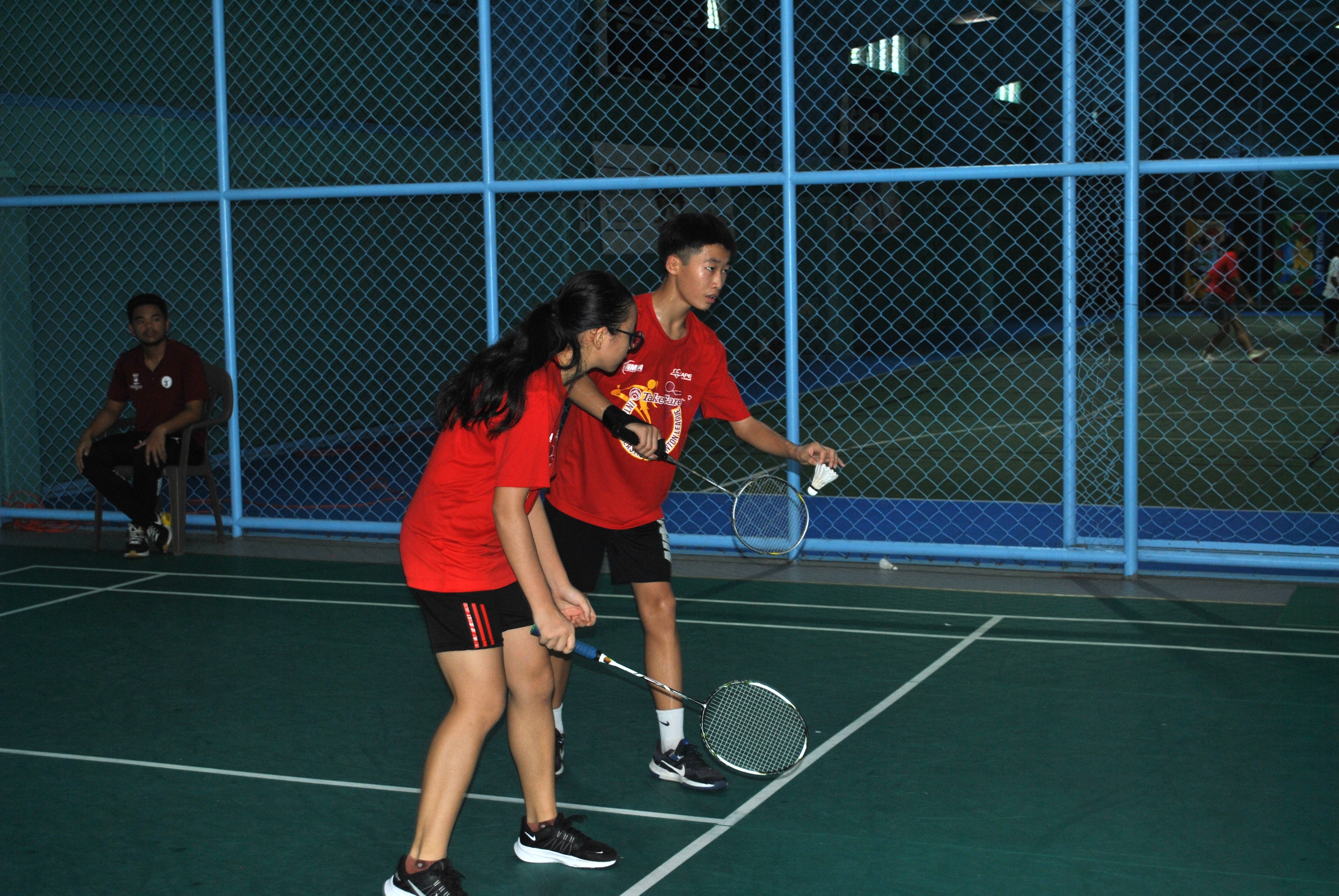 Agape’s Daniel Wang sets up for the serve alongside teammate Barbara Wang during the mixed doubles event of the middle school division championship of the TakeCare Interscholastic Badminton League at the TSL Sports Complex on Saturday.