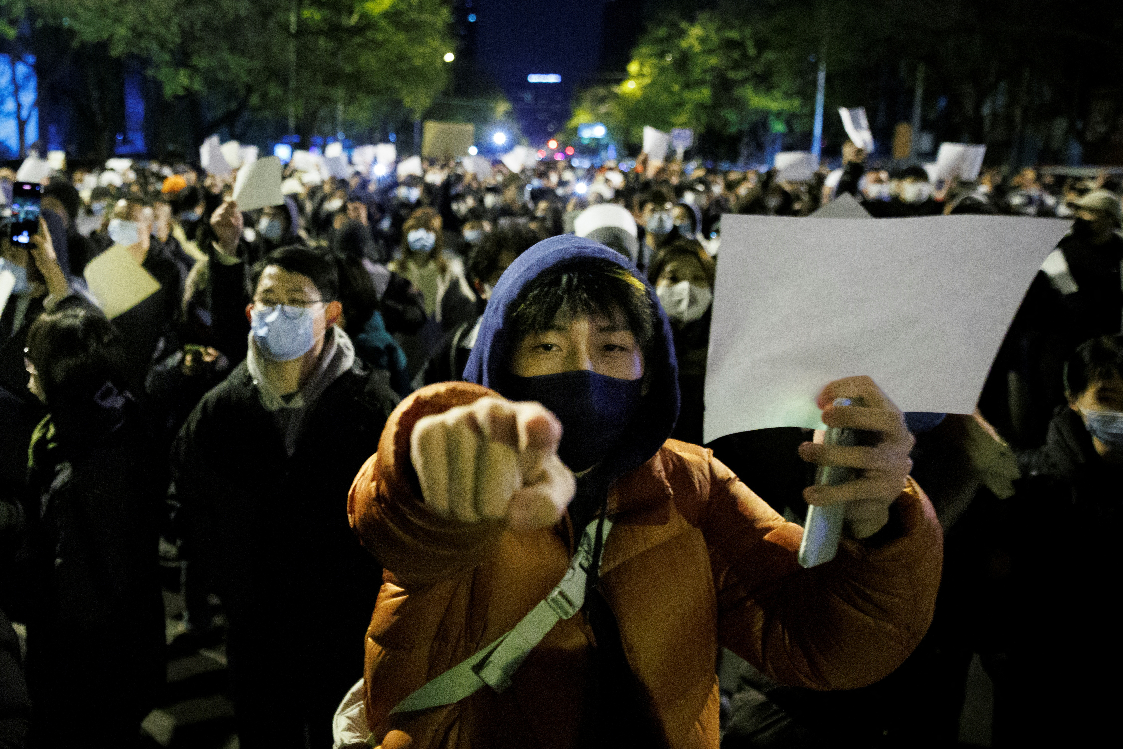 People hold white sheets of paper in protest over coronavirus disease restrictions, after a vigil for the victims of a fire in Urumqi, as outbreaks of Covid-19 continue, in Beijing, China, Nov. 27, 2022.