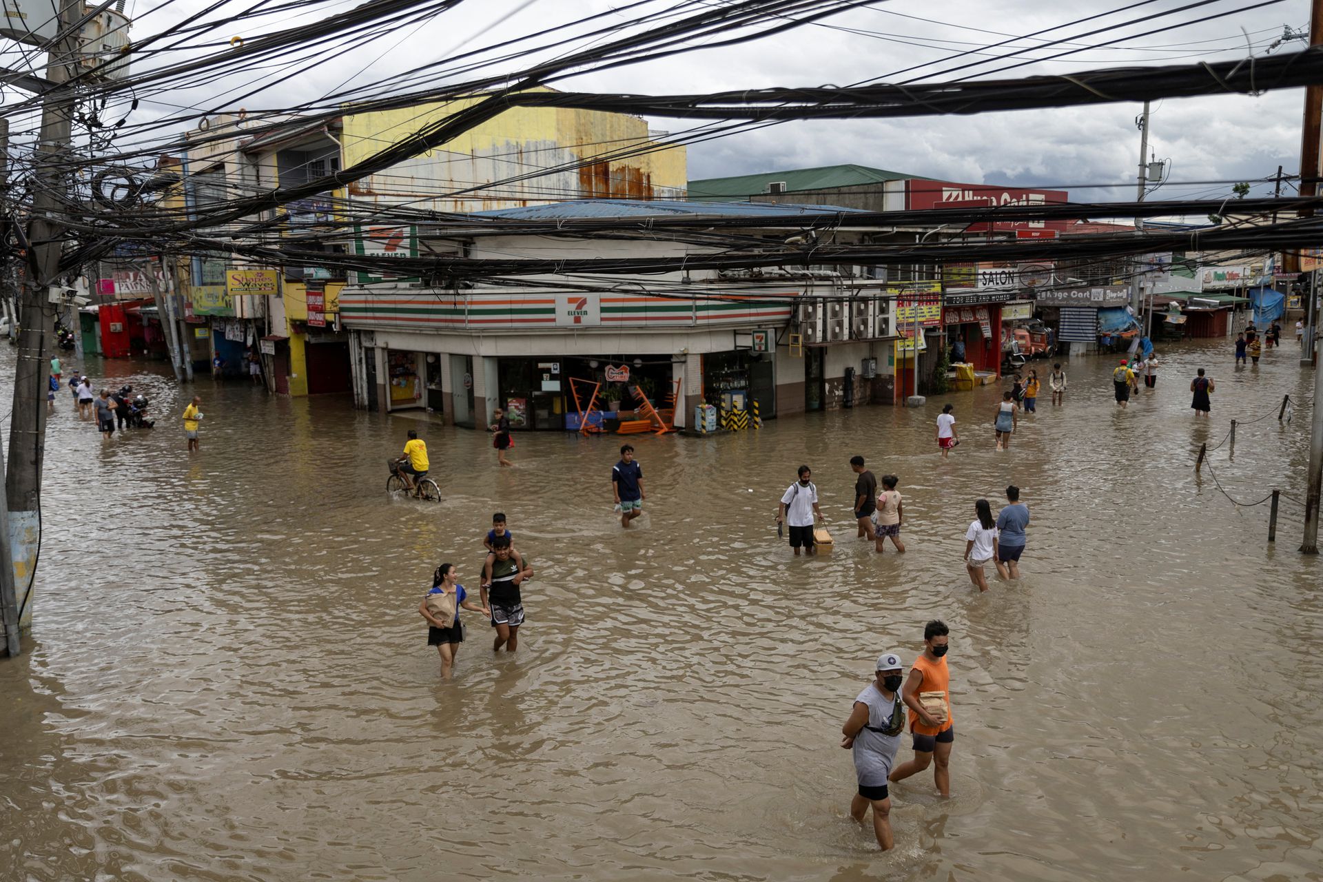 People wade through flooded streets following heavy rains tropical storm Nalgae, in Imus, Cavite province, south of Manila, the Philippines, Oct. 30, 2022.