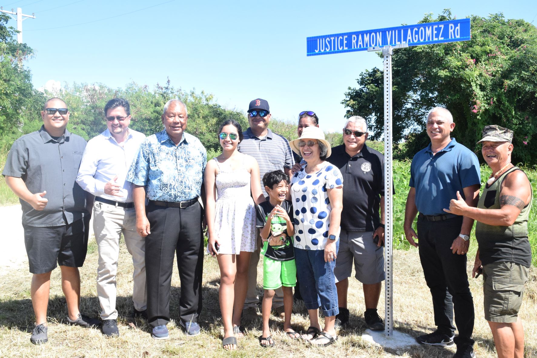 Saipan Mayor and Lt. Gov.-elect David M. Apatang, third left, Rep.-elect Vince Camacho, left, Rep. Edwin Propst, second left, and Rep. Joseph Flores, second right, pose for a photo with the  family of the late Justice Ramon G. Villagomez after renaming a street in Obyan in his honor.