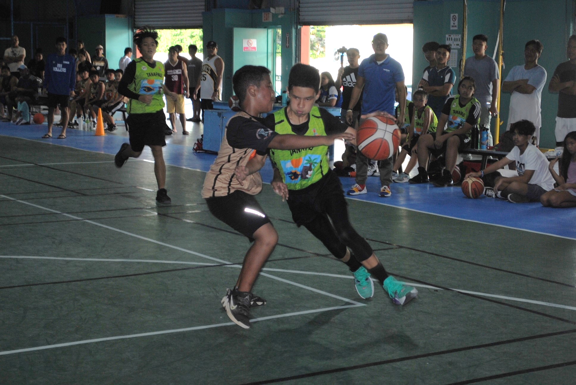 Tanapag's Lucas Esdrelon makes contact as he drives toward the hoop during a U13 boys division game of the 2022 Marianas Village Pride Basketball League Saturday at the TSL Sports Complex.