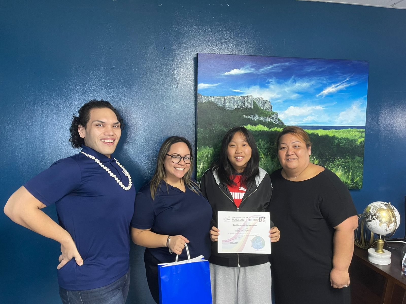 Marianas High School student and Pacifica Art Contest Traditional Category 2 winner Alyssa Kim was joined by school administrator Romolo Orsini and Melanie Sablan in accepting her award and cash prize from Pacifica Insurance's Dionne Camacho.