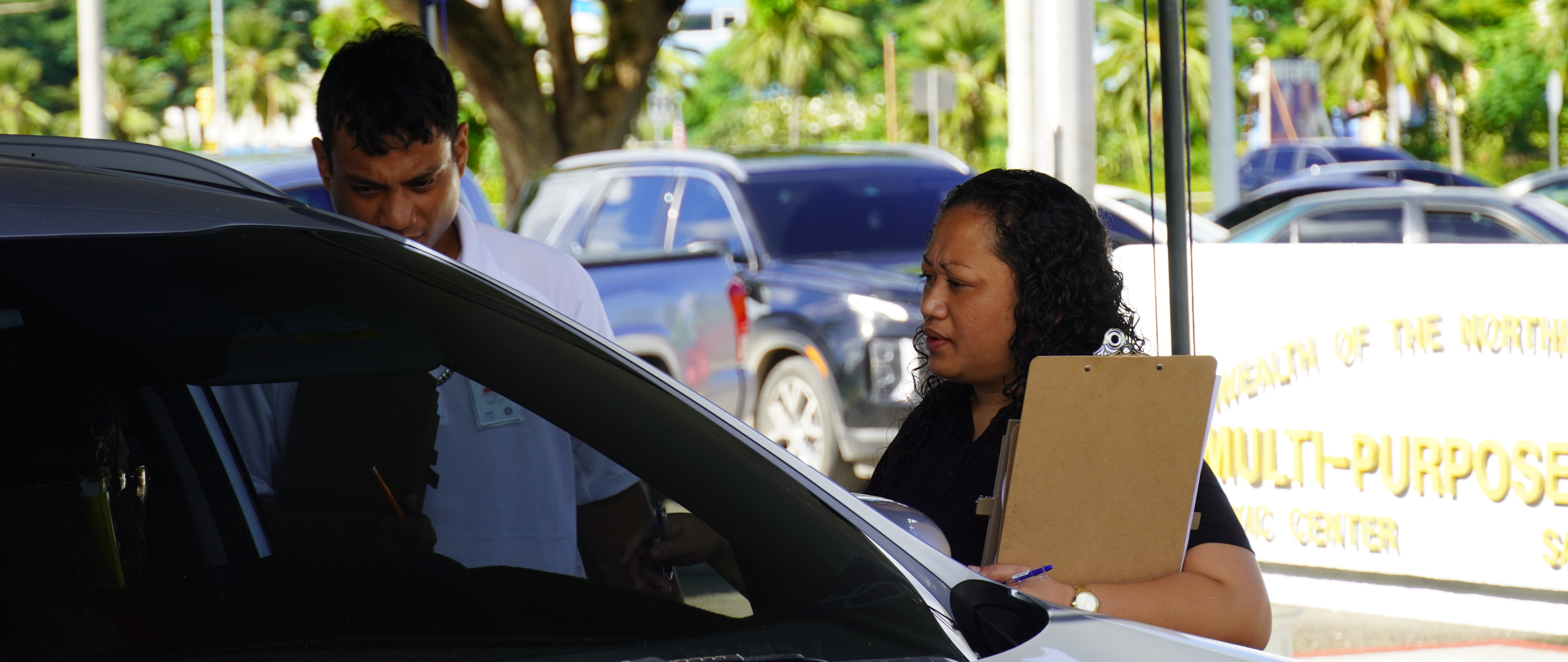 Commonwealth Election Commission Executive Director Kayla S. Igitol and a staffer assist a curbside voter outside the Gov. Pedro P. Tenorio Multi-Purpose Center in Susupe on Tuesday. 