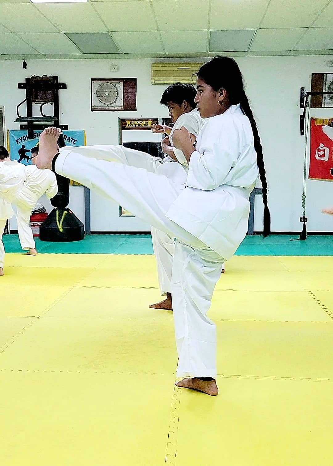Maja Diaz executes a front kick at a Kyokushin Karate Dojo.