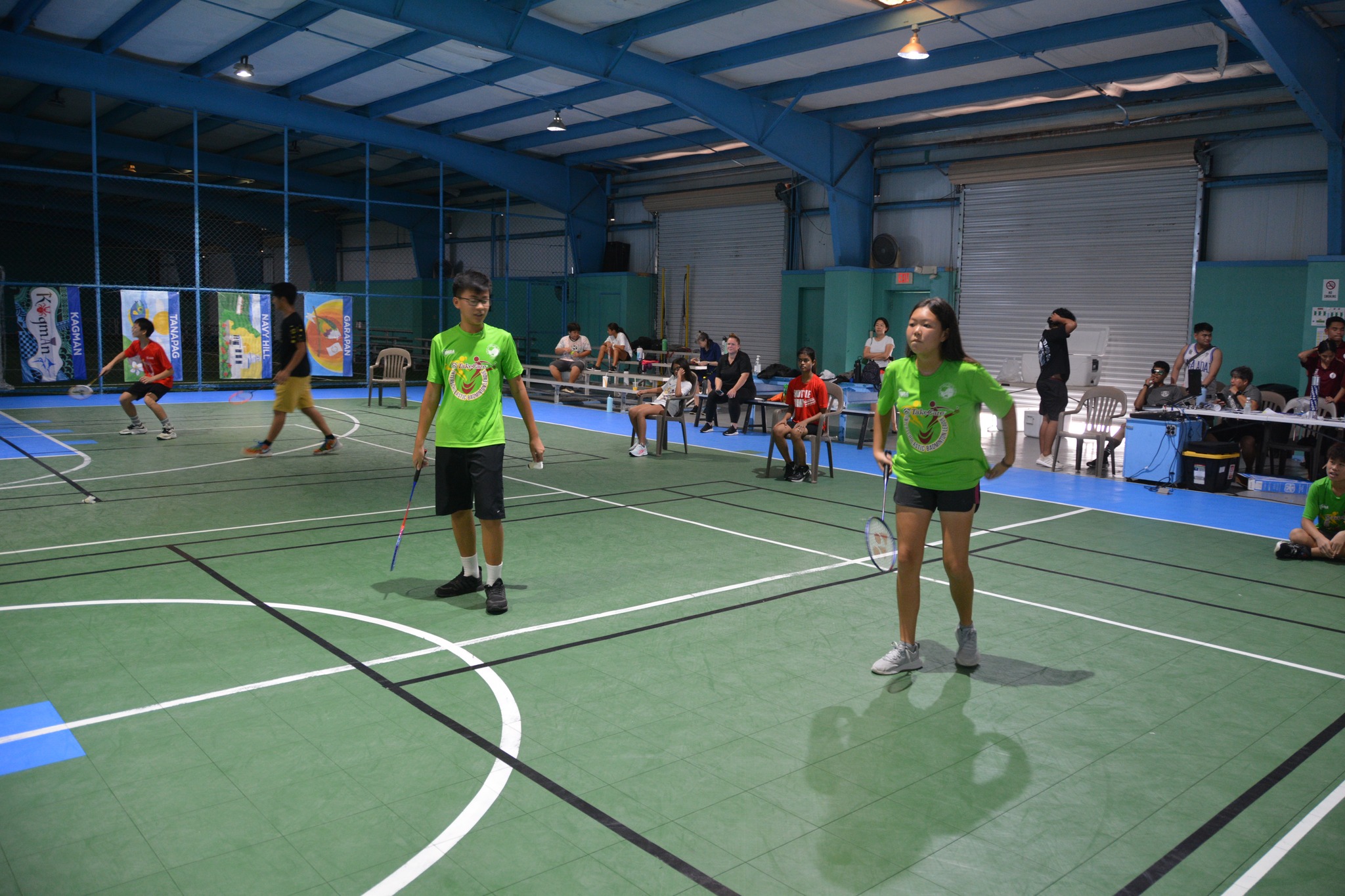 SIS players prepare for the serve in a TakeCare Interscholastic Badminton League middle school division mixed doubles match at the TSL Sports Complex.