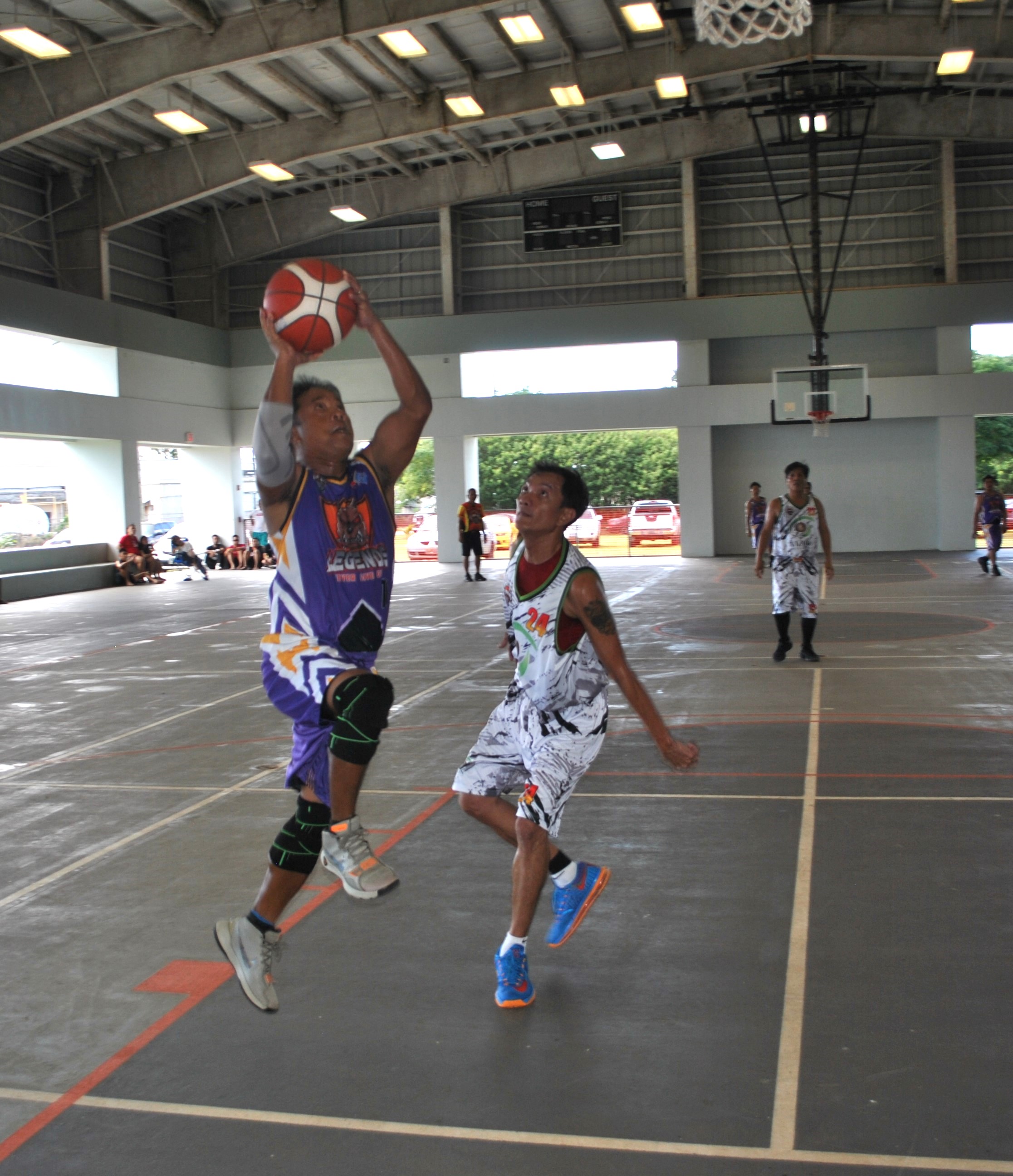 Legends Elite's Ed Guinto extends for the finish during a masters division game of the Legends Sports Association Invitational Basketball League on Saturday at the Koblerville gym.