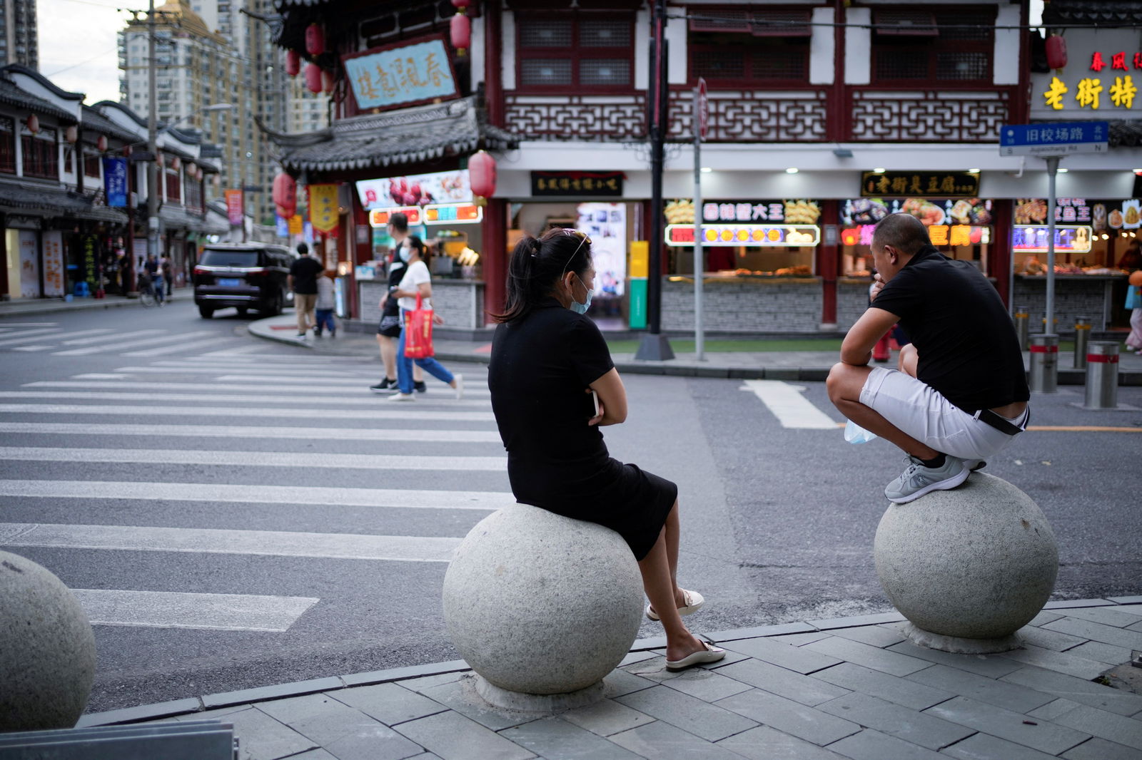 People rest on stone barricades on a street in Shanghai, China, Sept. 9, 2022.