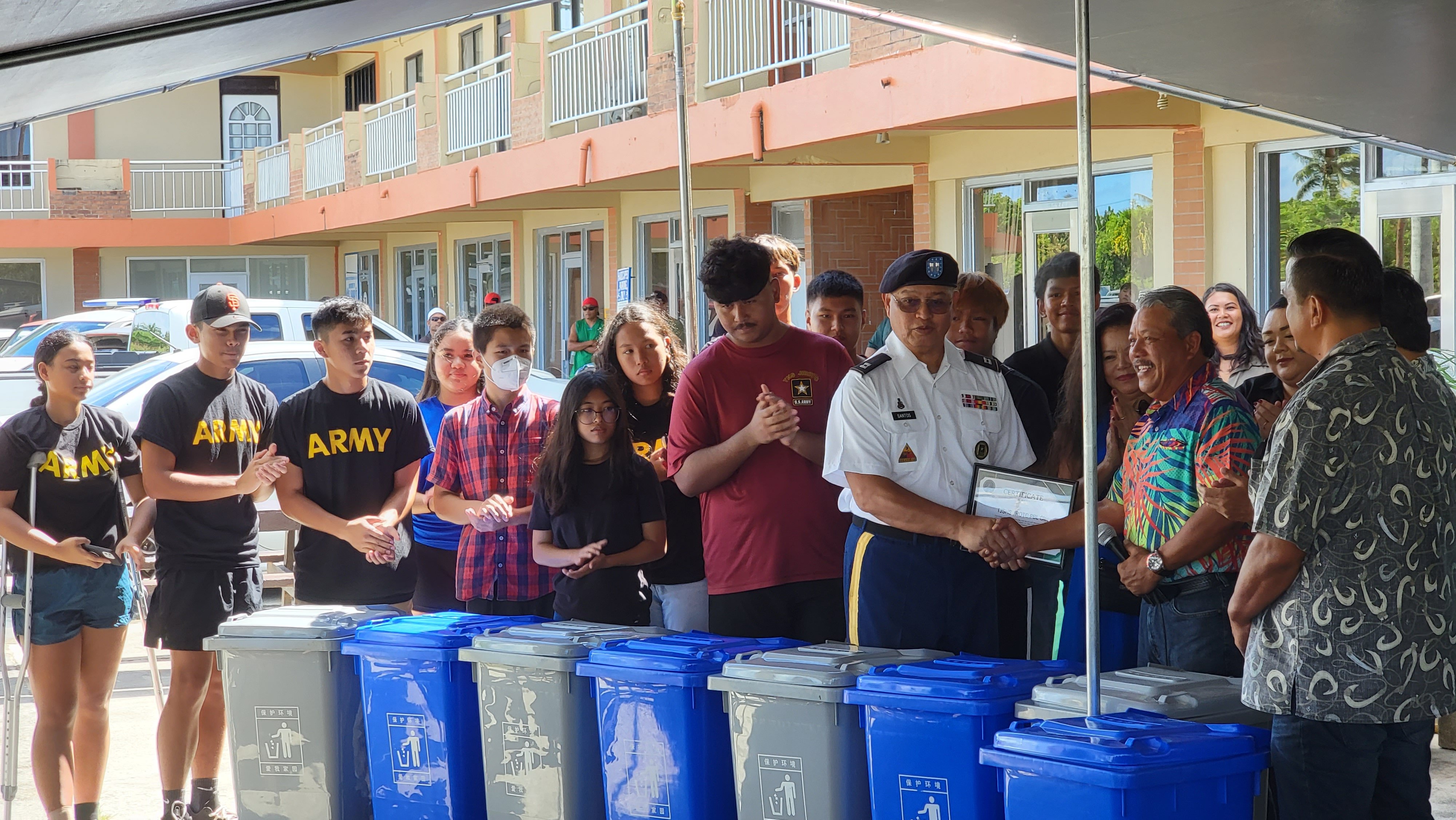 Mayor of Tinian and Aguiguan Edwin P. Aldan, fourth right, shakes hands with Tinian Junior Senior High School Junior Reserve Officers' Training Corps Instructor Capt. Joseph Santos as the Office of the Mayor of Tinian and Aguiguan turned over eight recycling bins and presents a Certificate of Recognition to the TJSHS JROTC Stallion Battalion.