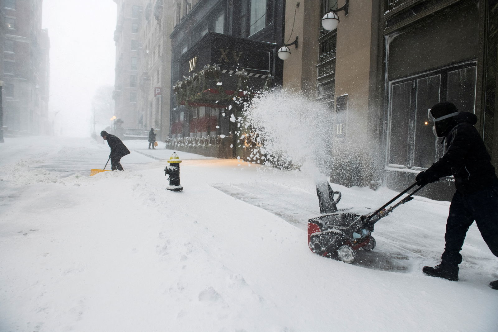 XV Beacon hotel workers clear snow during a Nor'easter storm in Boston, Massachusetts, Jan. 29, 2022.