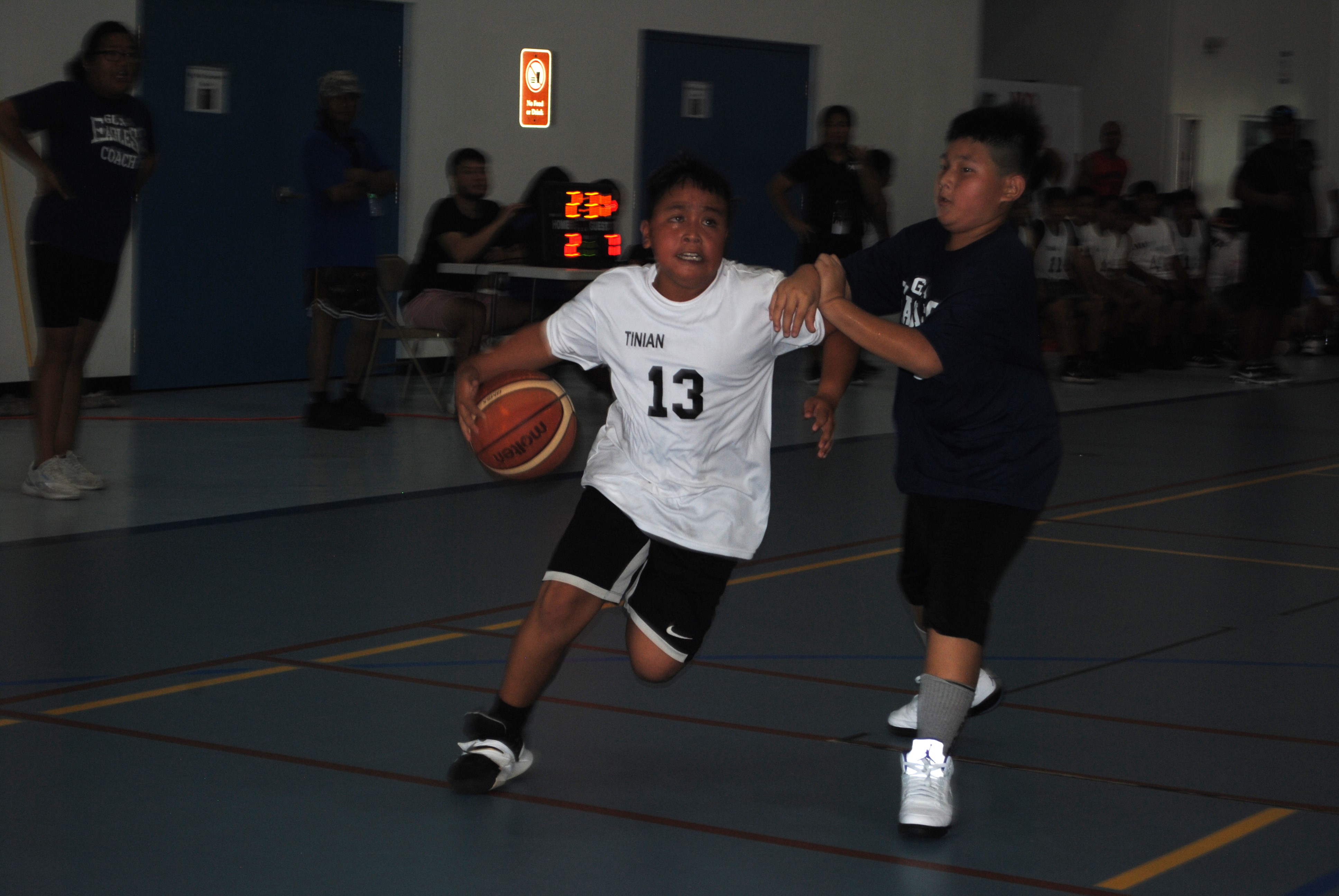 Tinian's Traven Evangelista protects the ball against a GCA defender during an elementary school division game of the IT&E Interscholastic Basketball League on Saturday at the MHS gym.