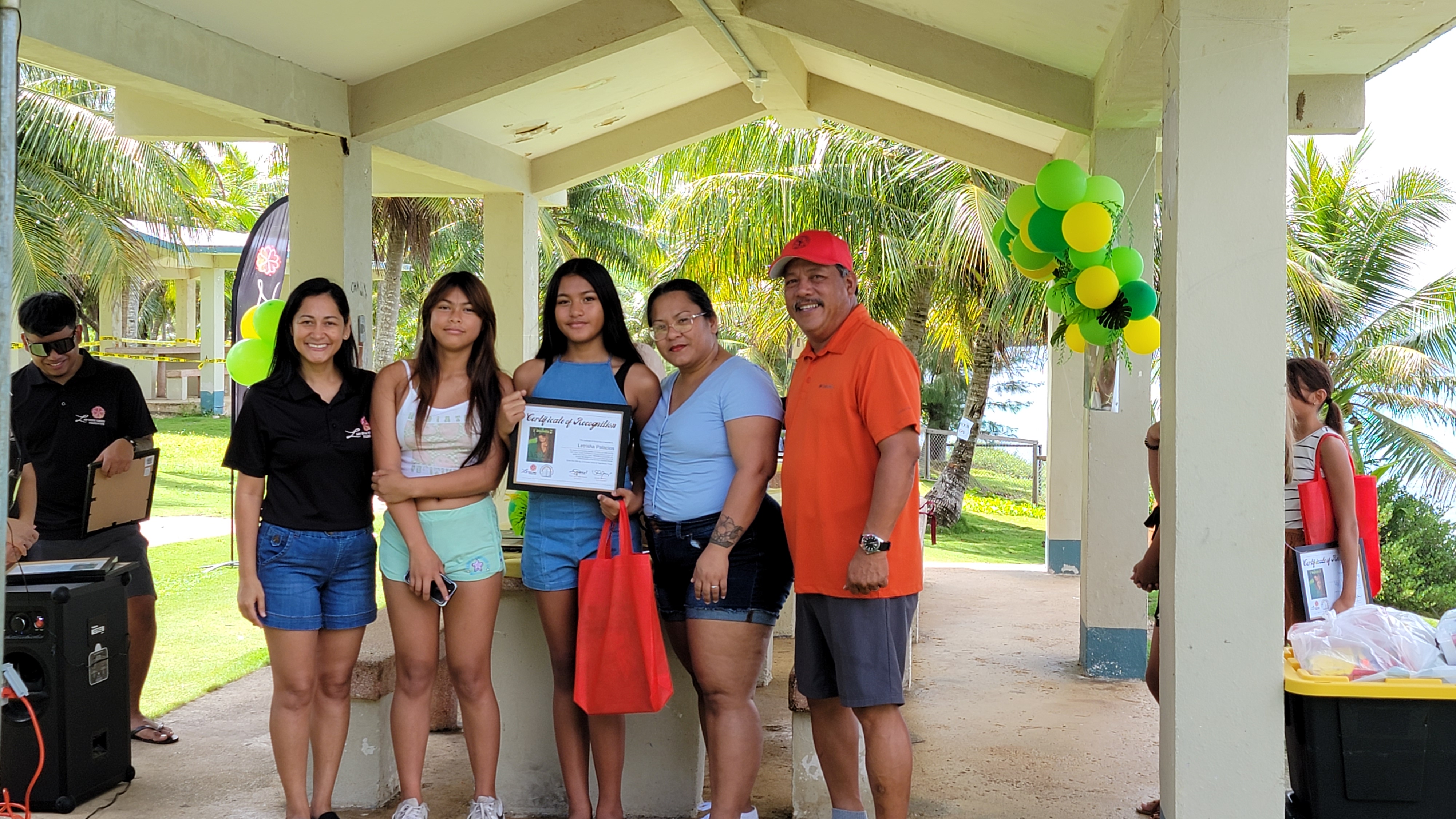 I Duendis 2 author Letrisha Palacios receives her certificate of recognition from first lady Diann Torres. Also in photo are Tinian Mayor Edwin Aldan and family members.