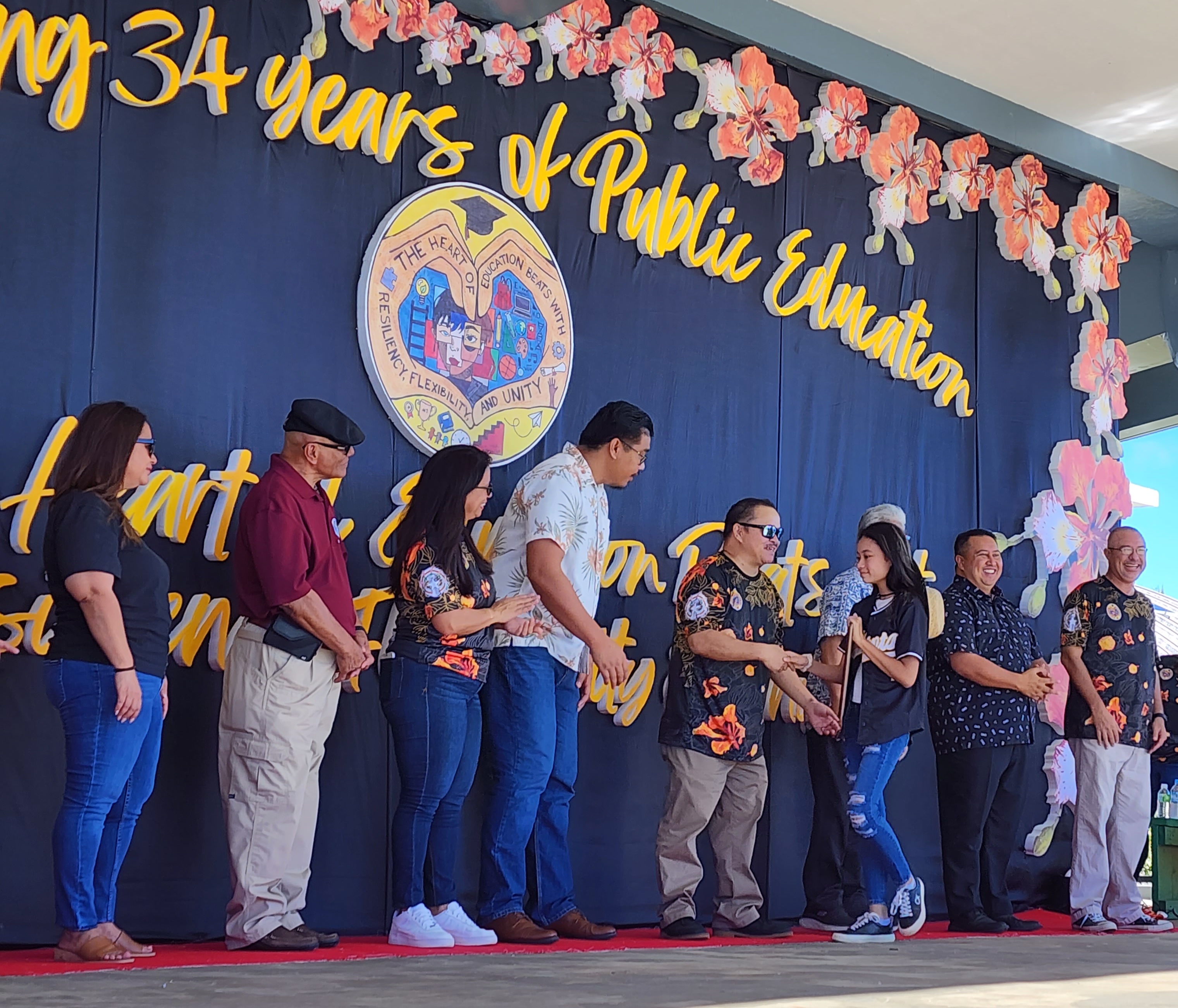 Education Day Essay Winner Ysharei Lizama Sanje is congratulated by BOE Chairman Gregory Pat Borja, Gov. Ralph DLG Torres, Lt. Gov. Arnold I. Palacios, Commissioner of Education Dr. Alfred B. Ada, BOE Vice Chairman Antonio L. Borja, Secretary/Treasurer Maisie B. Tenorio, Board Member Herman Atalig and Senior Director Yvonne Pangelinan.