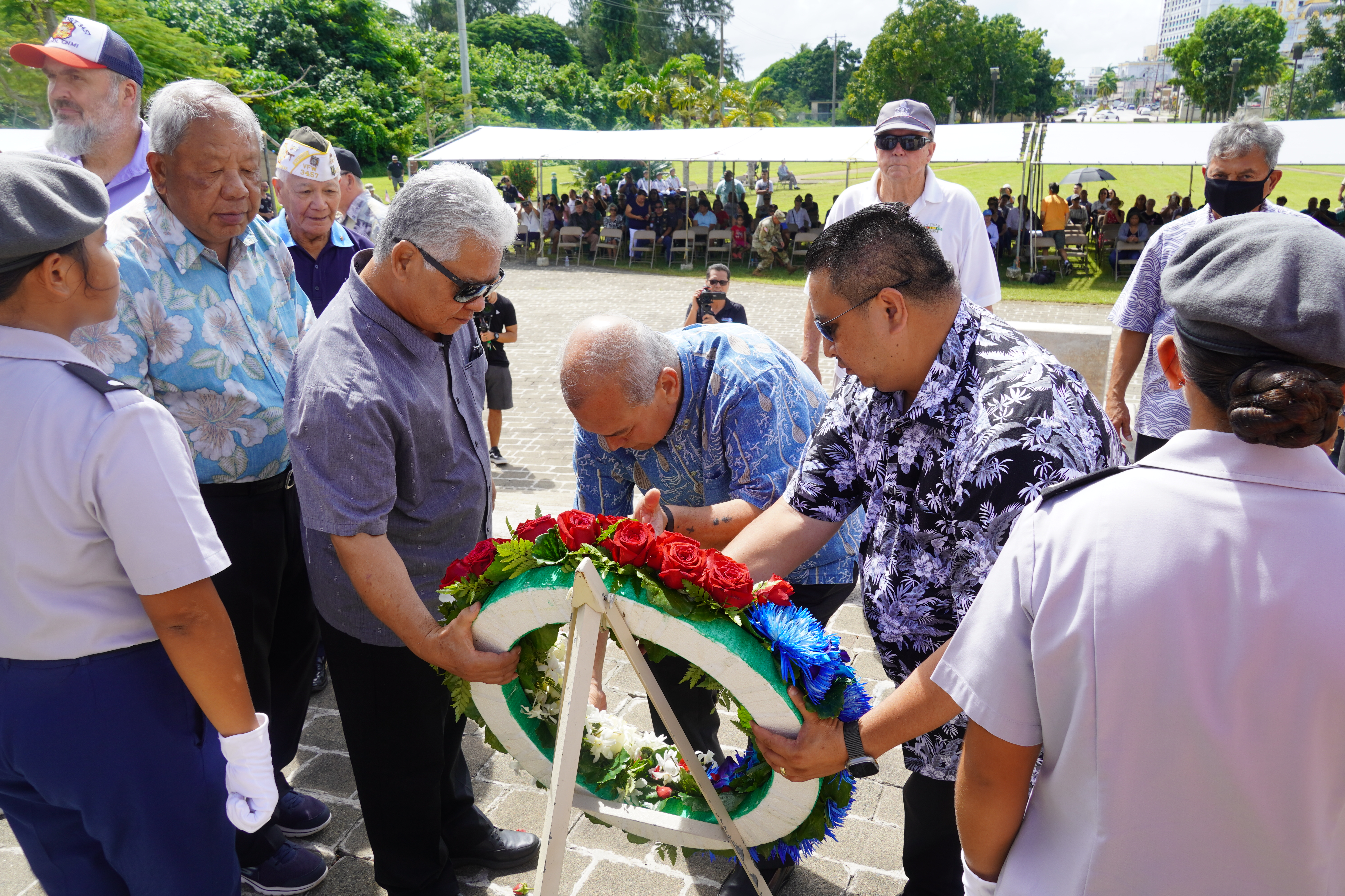 Gov. Ralph DLG Torres, Lt. Gov. Arnold I. Palacios, and U.S. Congressman Gregorio Kilili Camacho Sablan with the ceremonial wreath as other officials, veterans and cadets look on.