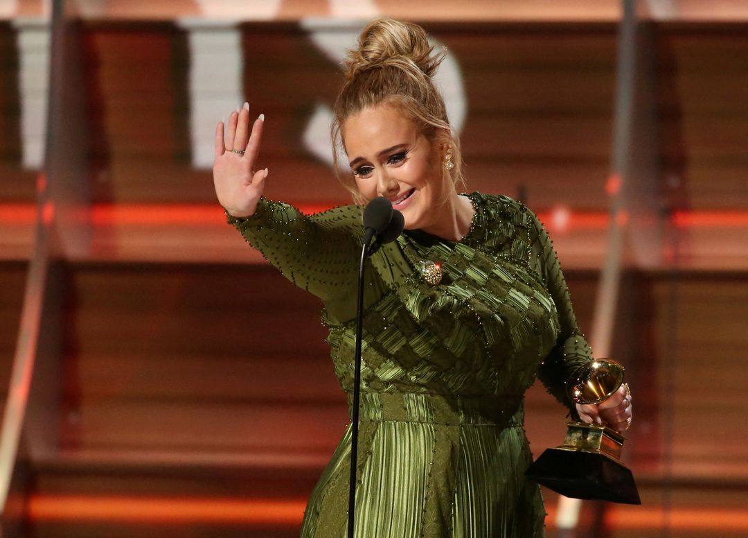 Adele waves to singer Beyonce who is in the audience as she and co-song writer Greg Kurstin — not pictured —  accept the Grammy for Song of the Year for "Hello" at the 59th Annual Grammy Awards in Los Angeles, California, Feb. 12, 2017.