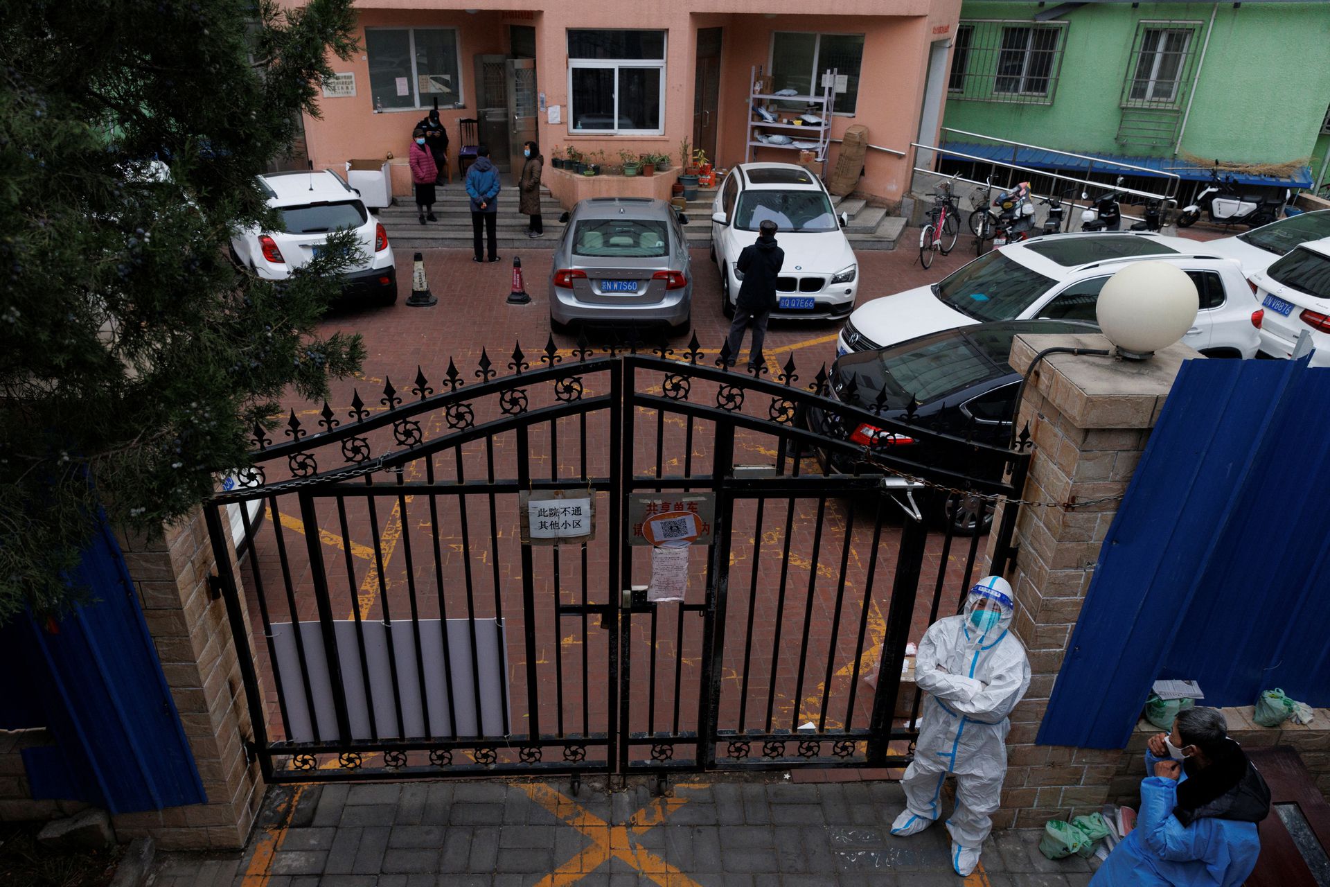 A pandemic prevention worker in a protective suit keeps watch at a residential compound after it was locked down as outbreaks of coronavirus disease continue in Beijing, Nov. 18, 2022.