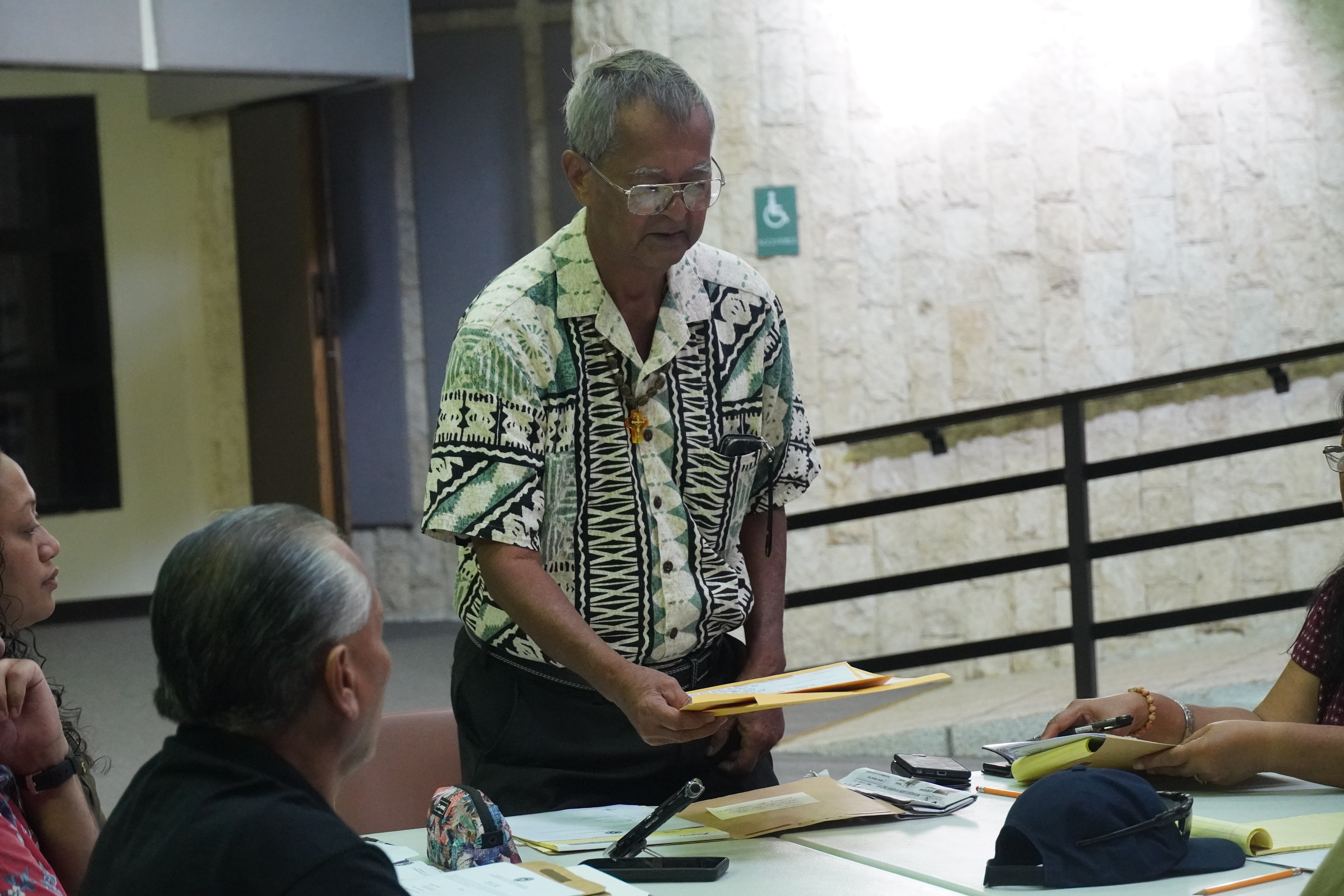Commonwealth Election Commission Chair Jesus I. Sablan holds two provisional Northern Islands ballots during a meeting on Friday.