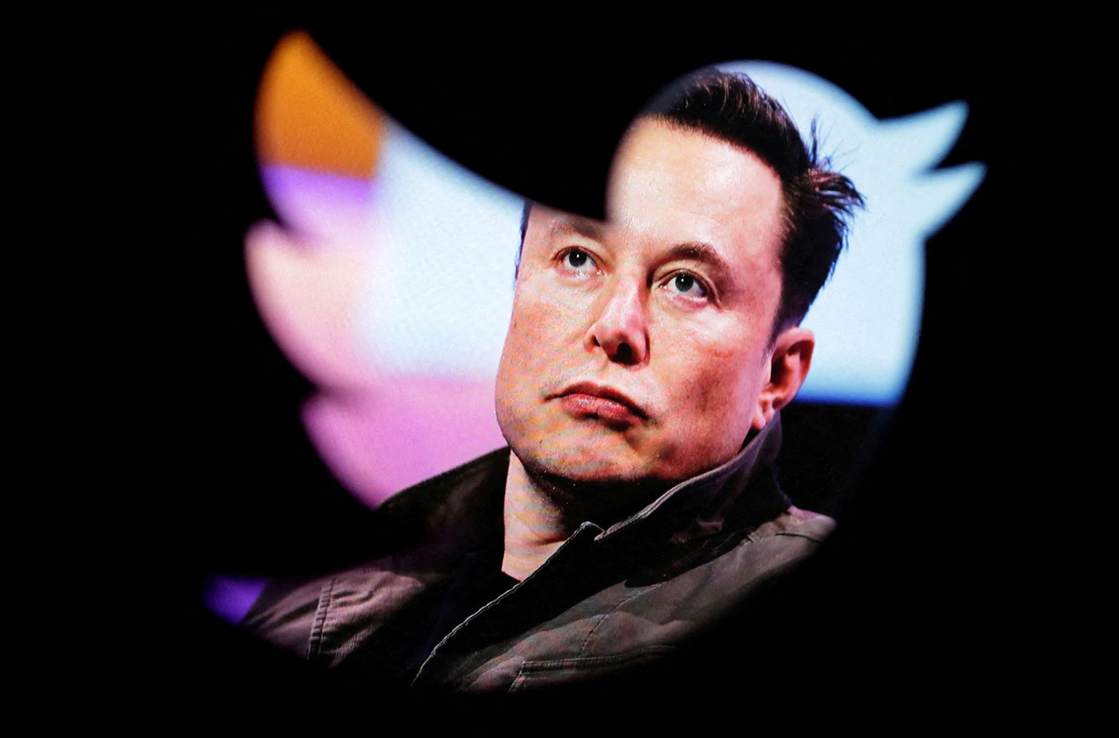 Elon Musk's photo is seen through a Twitter logo in this illustration taken on Oct. 28, 2022.