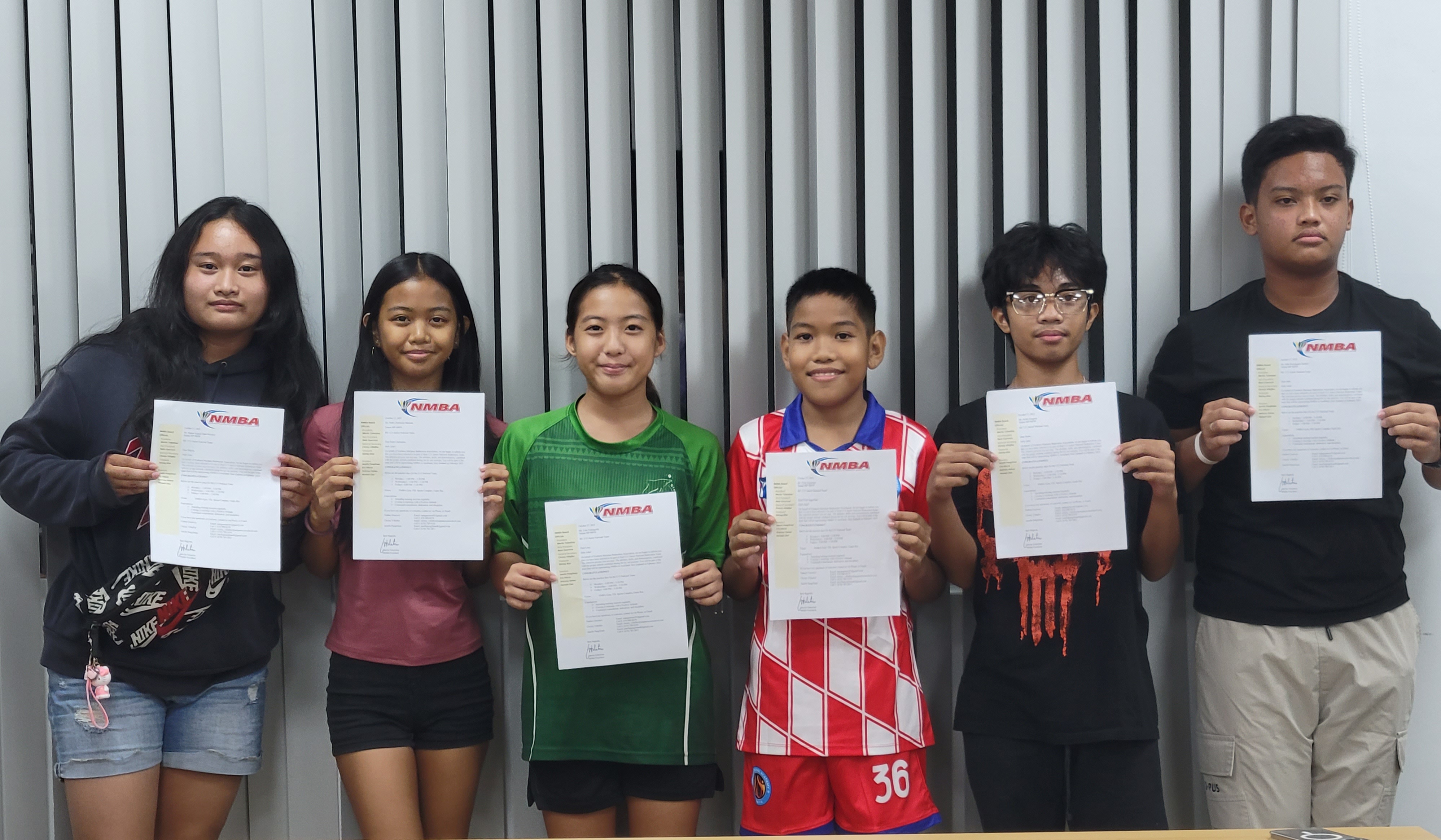 From left, Shaina Angelo Malonzo, Ruth Charmaine Bautista, Lina Tsukagoshi, Evan Seguritan, Justin Gragasin, and Jude Mallari show the letter from the Northern Marianas Badminton Association confirming their selection to the NMI Junior National Badminton Team.