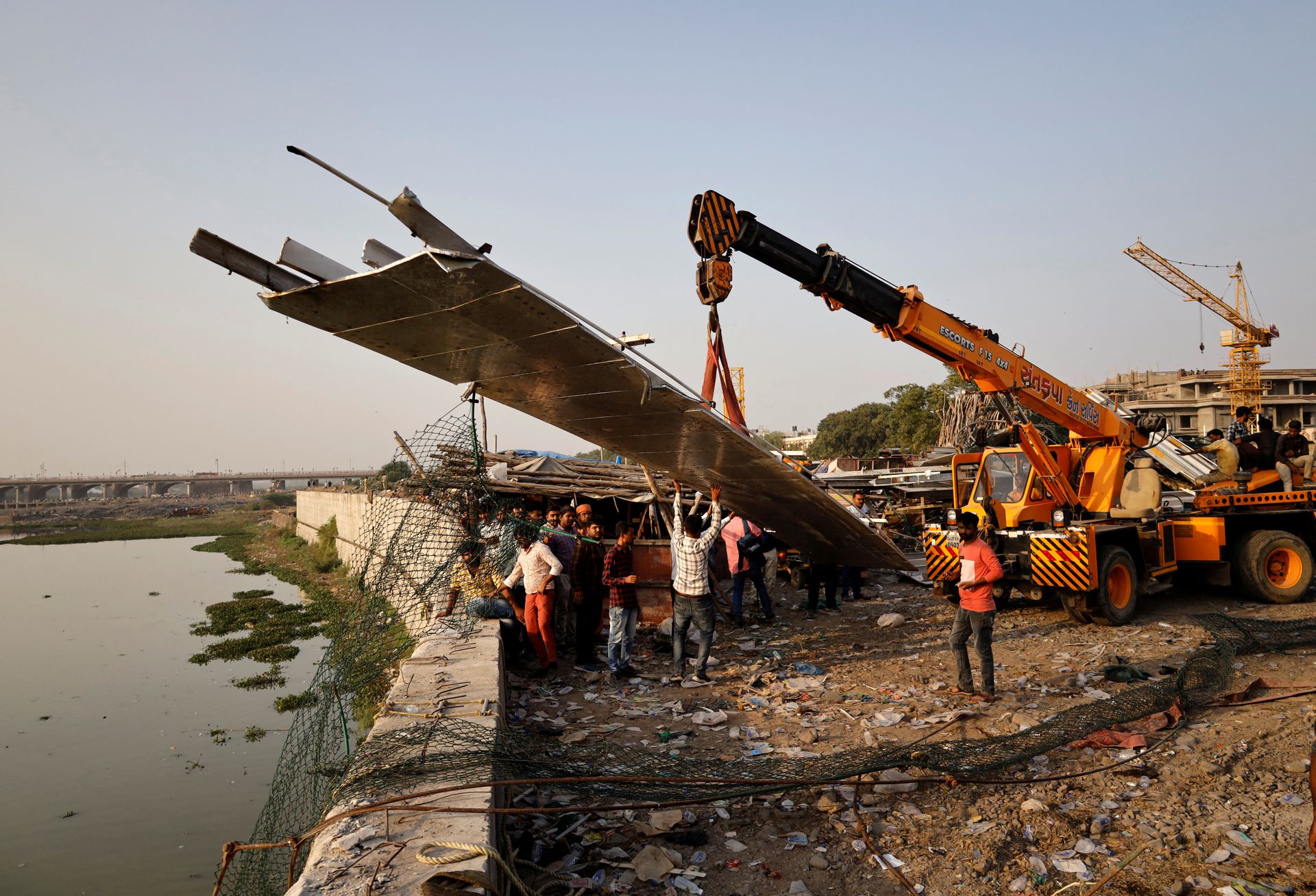 People remove debris after a suspension bridge collapsed in Morbi town in the western state of Gujarat, India, Oct. 31, 2022.