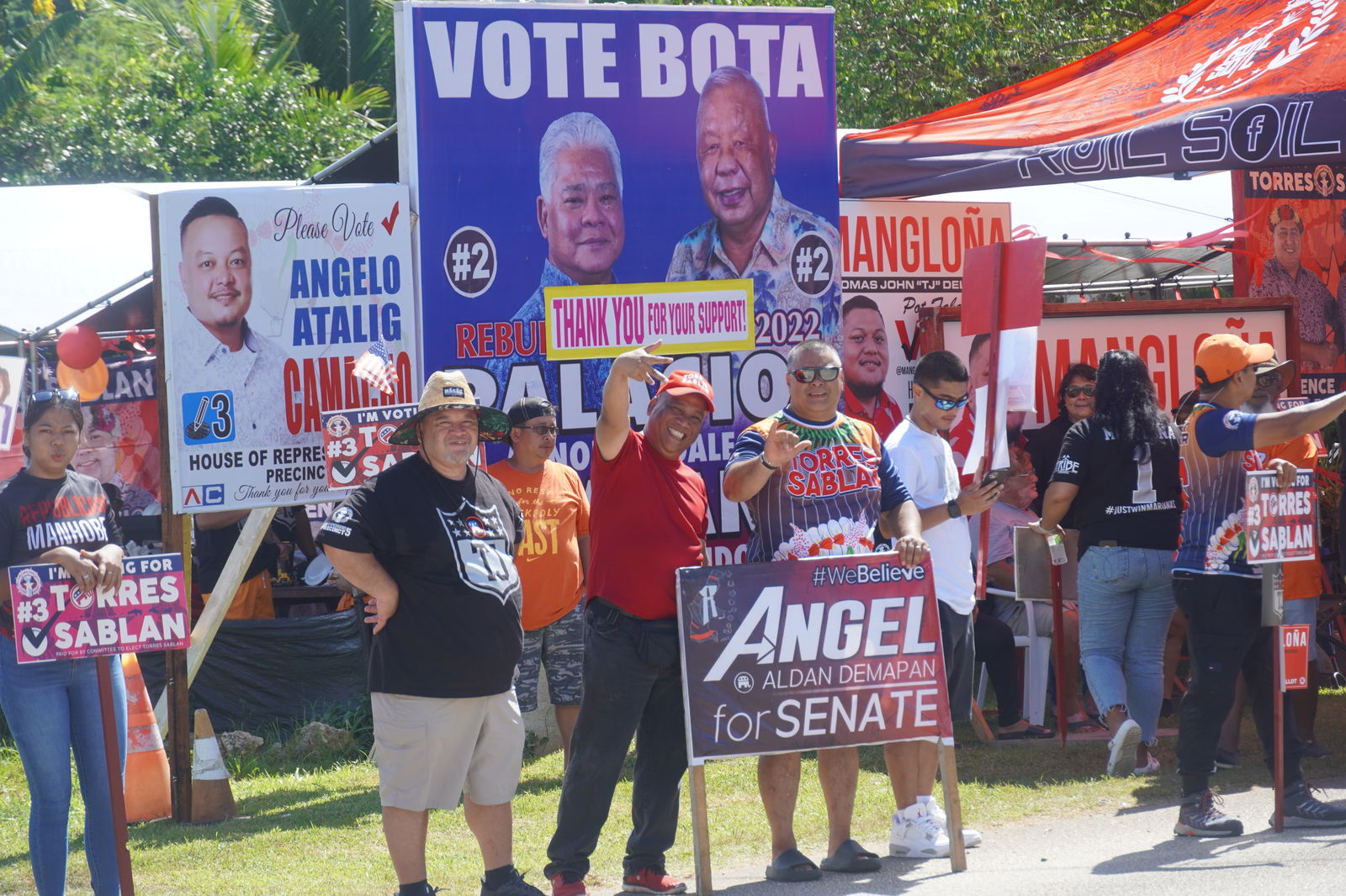 Republican supporters, including Department of Public Lands Secretary Sixto K. Igisomar and Department of Finance Secretary David DLG Atalig, wave to passersby in Kagman.
