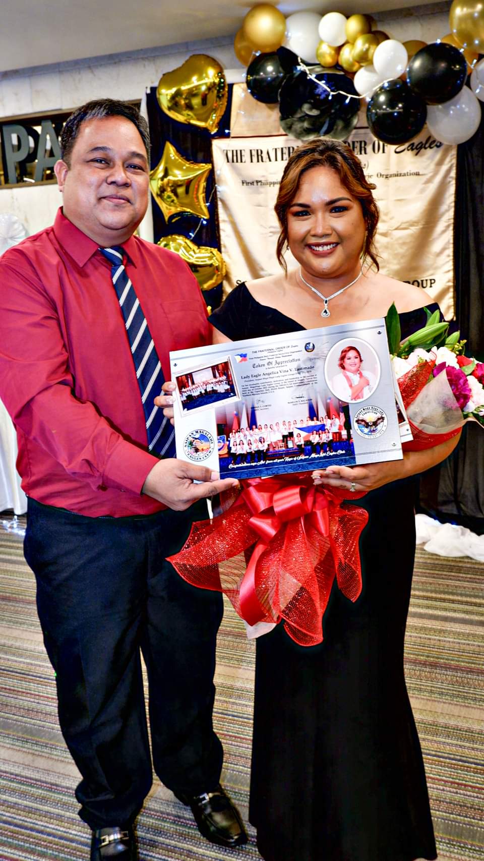 Saipan Maga'Haga Lady Eagles Group President Angelica Lastimado receives a plaque of appreciation from Saipan Magalahi  President Eagle Marlon  Regaton.