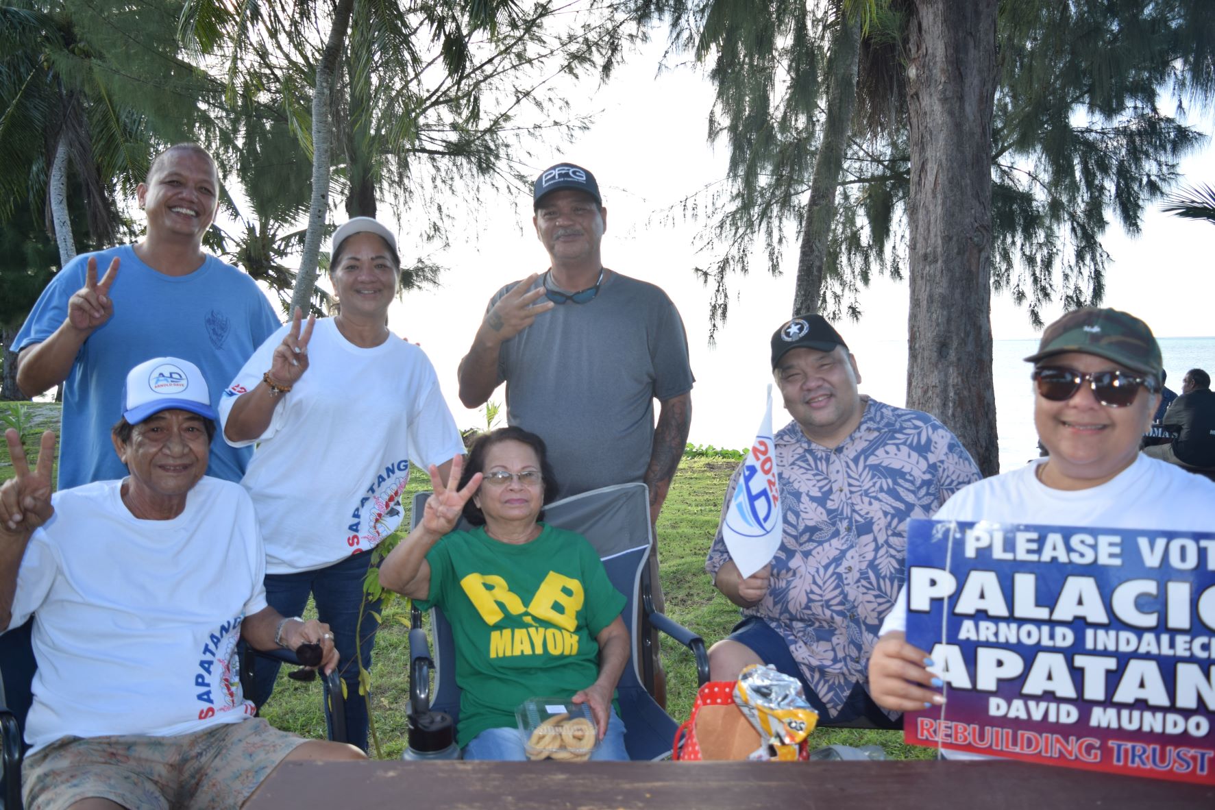 Tinian independent senatorial candidate Thomasa P. Mendiola, second left, standing, pose for a photo with former Tinian Mayors James Mendiola, seated left, and Patrick San Nicolas, seated second right, Precinct 1 House candidate Vincent "Kobre" Aldan, left, and supporters during the AD 2022 campaign rally at Minatchom Atdao on Sunday.