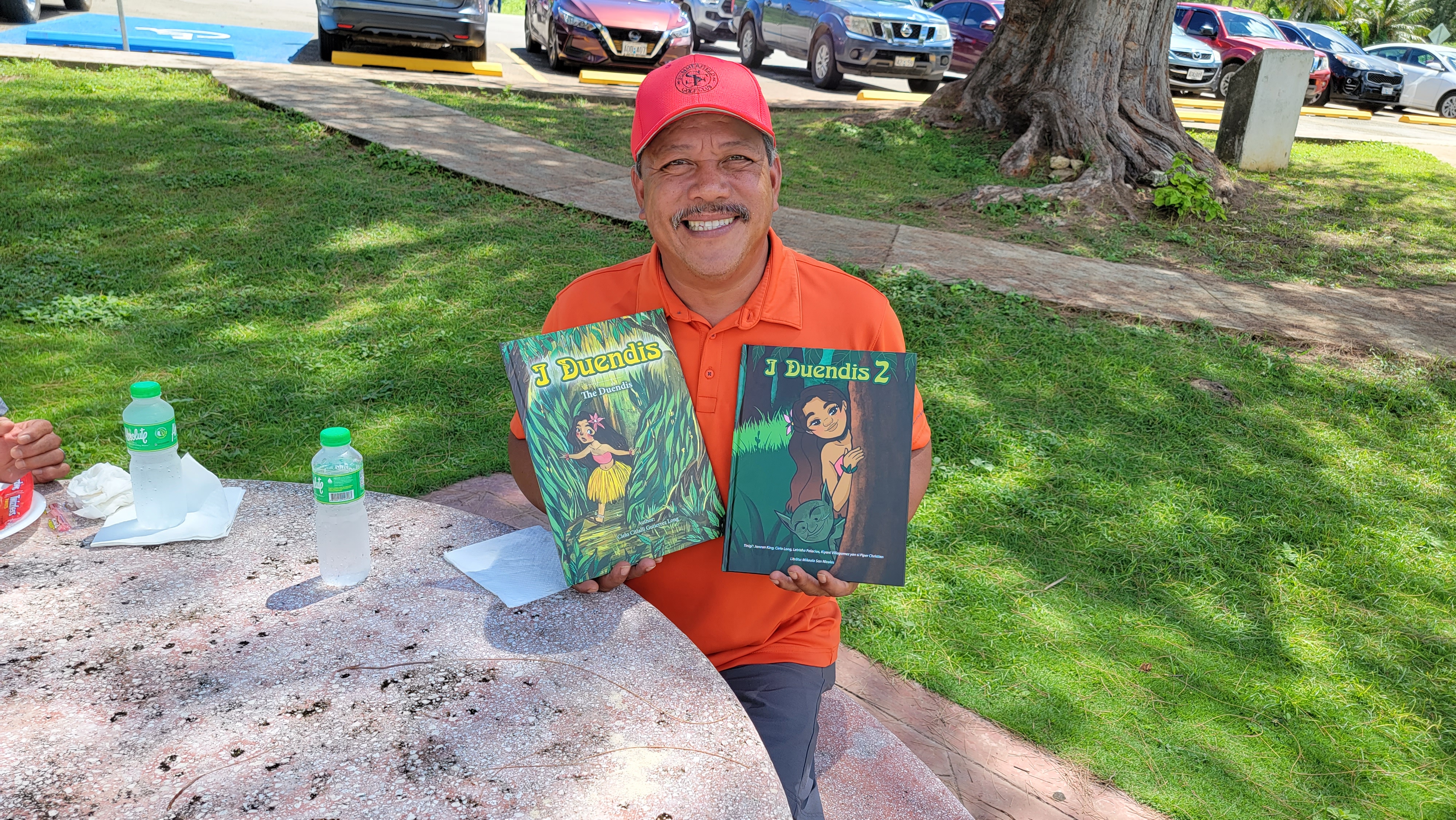 Mayor Edwin Aldan holds copies of I Duendis I and 2 written by young authors from Tinian.