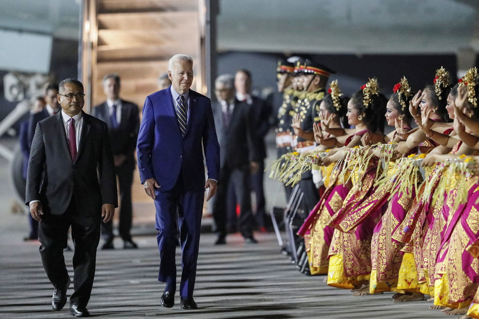 President Joe Biden walks as Balinese dancers perform during his arrival for the G20 Summit at Ngurah Rai International airport in Bali, Indonesia, Nov. 13, 2022.