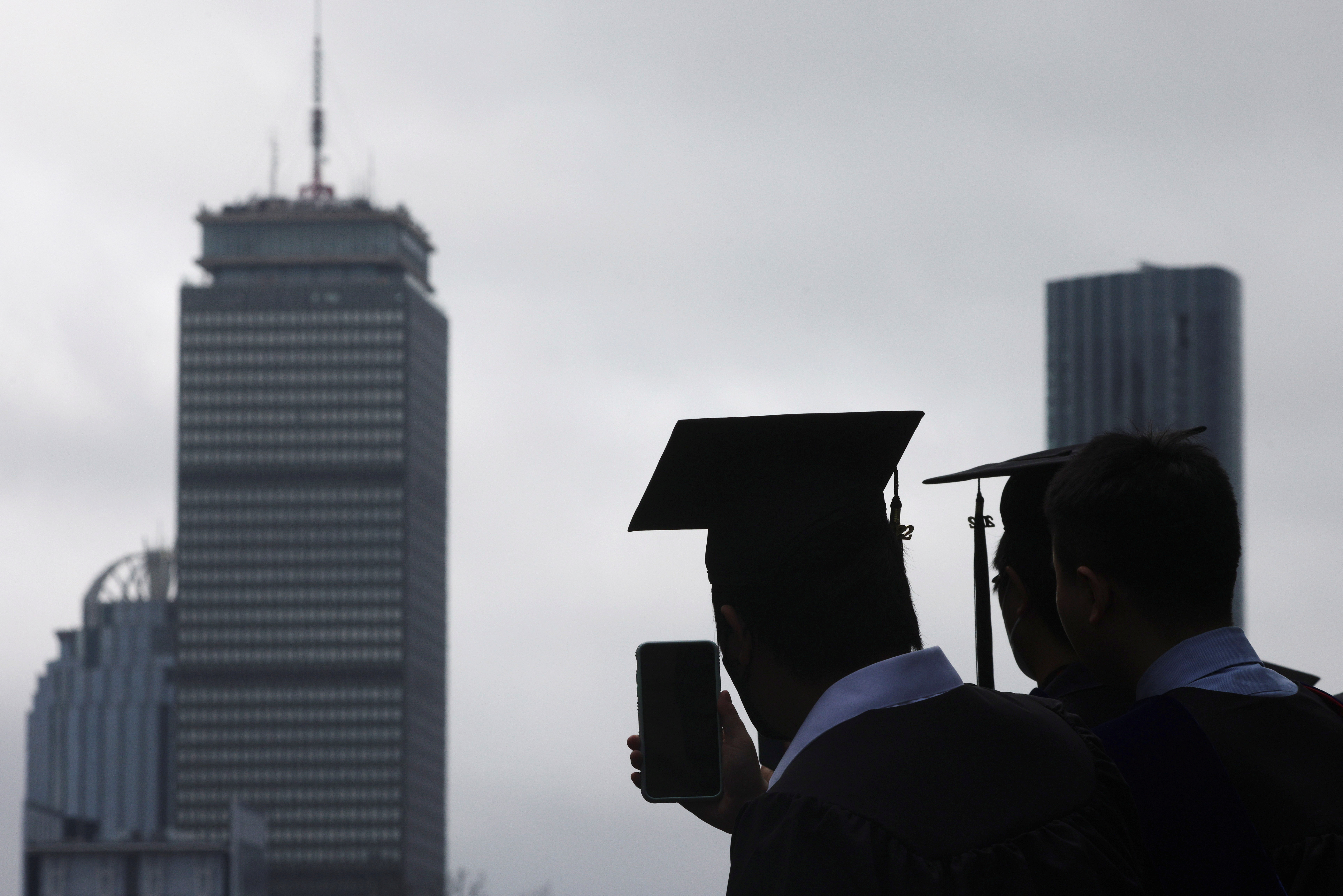 A graduating student records the academic procession during the Commencement ceremony at the Massachusetts Institute of Technology in Cambridge, Massachusetts, May 27, 2022.