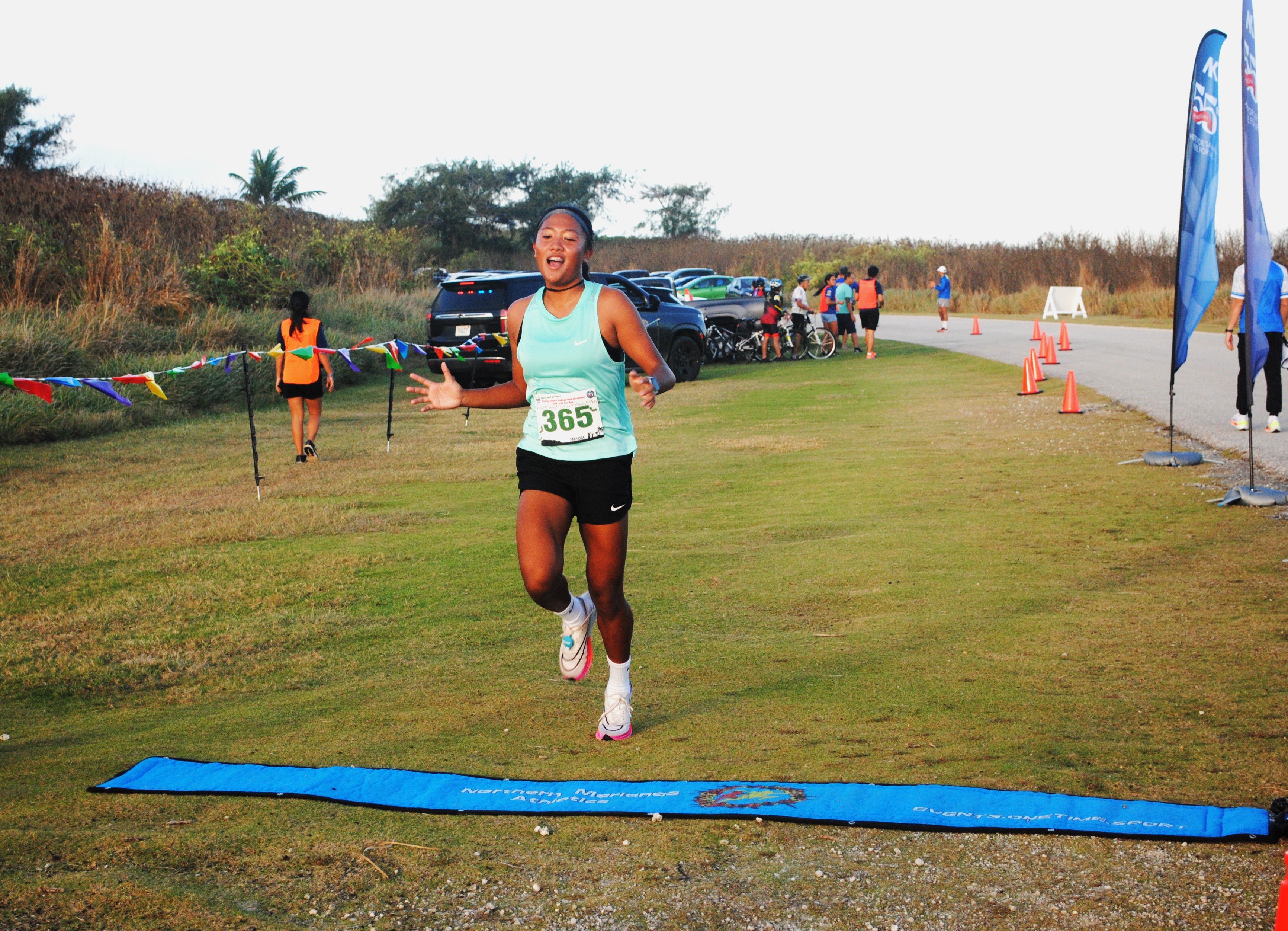 Kaithlyn Chavez crosses the finish line of the AK 5.5K Fun Run on Saturday at Banzai Cliff.