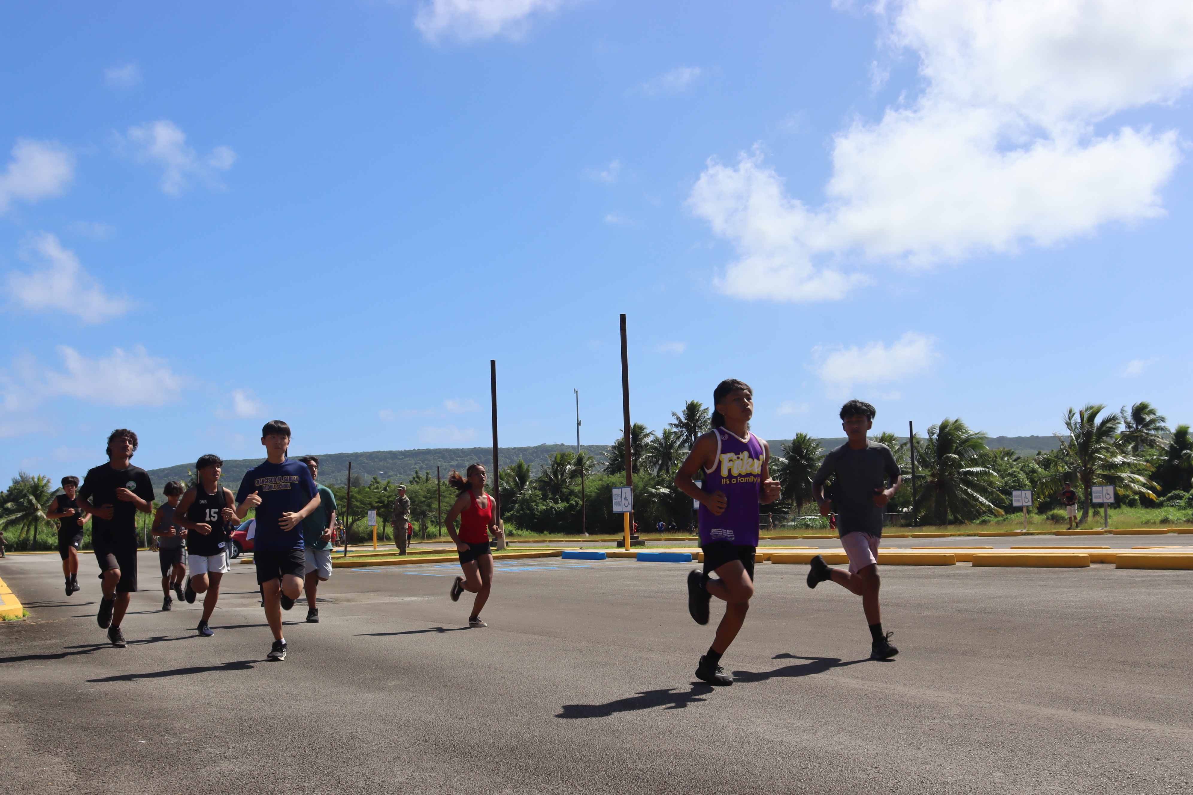 Students running on the Tinian High School parking lot as they compete in the grueling 1-Mile Run.